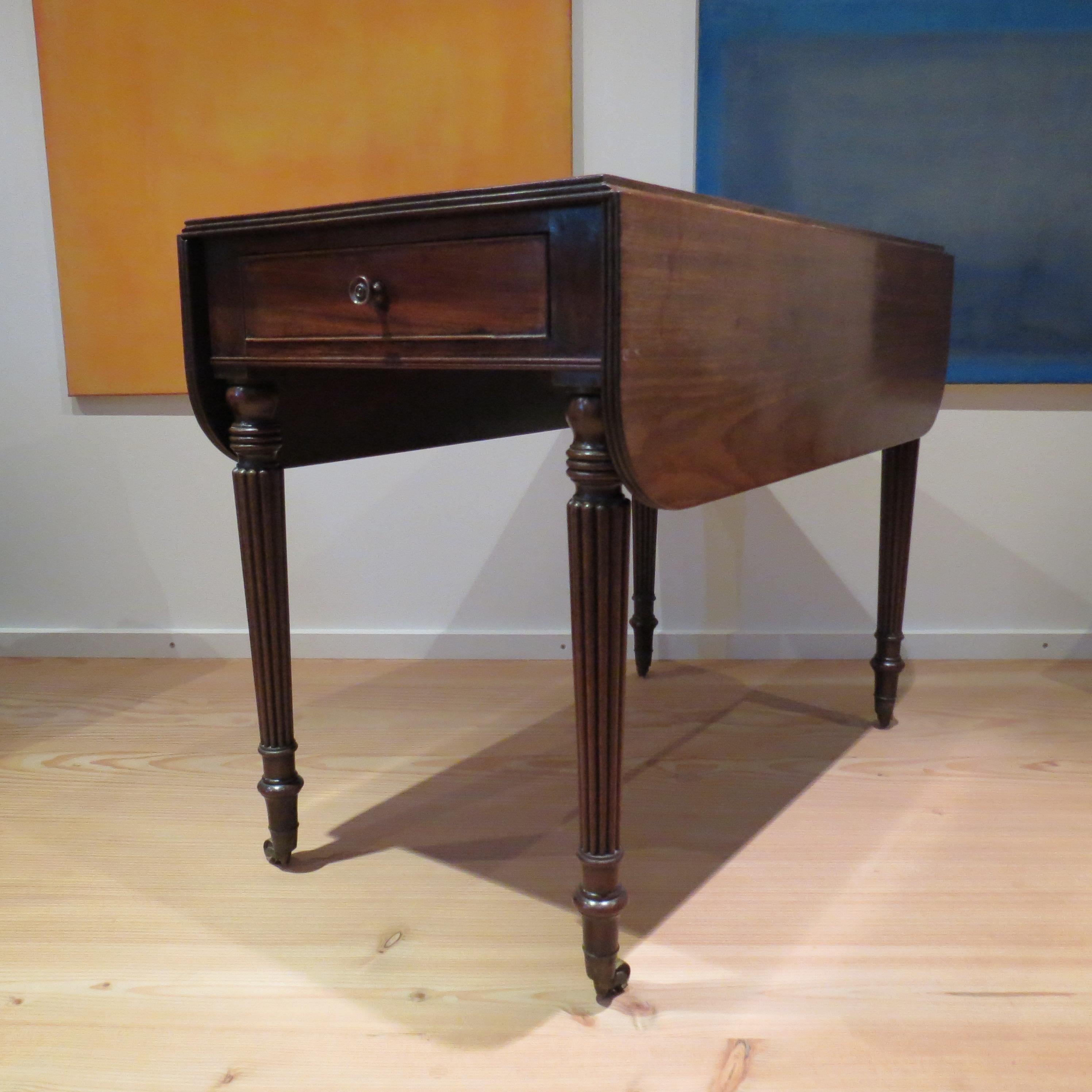 Wonderful antique Pembroke table attributed to Gillows Lancaster.  Very good quality, with drop leaf top allowing versatility to the piece.  The reeded legs with three rings to the top and double reeded beading below the drawer are indicative of