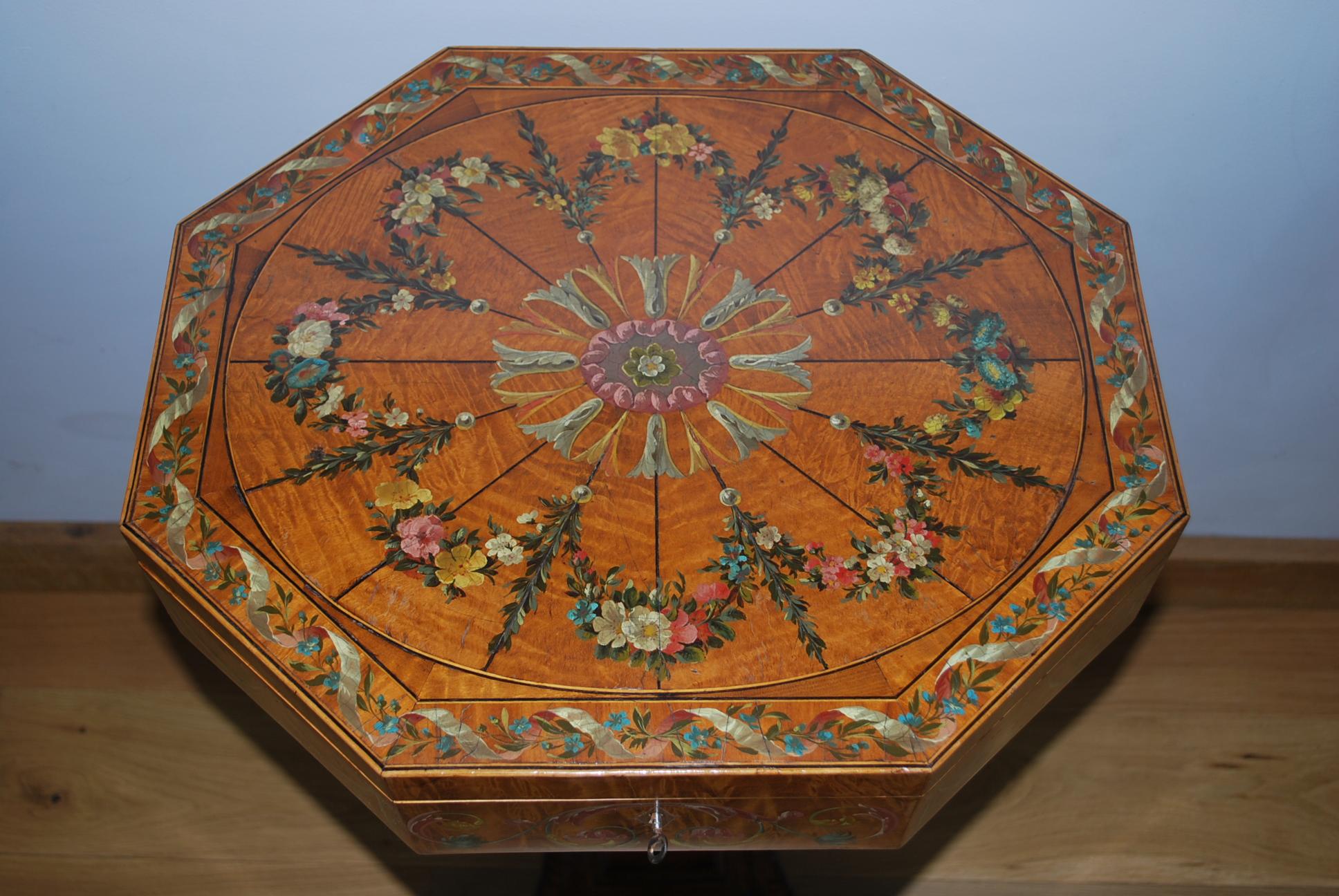This is a fine quality polychrome antique work table, standing on a platform base. It has a very fine painted decoration all over with a silk lined interior.