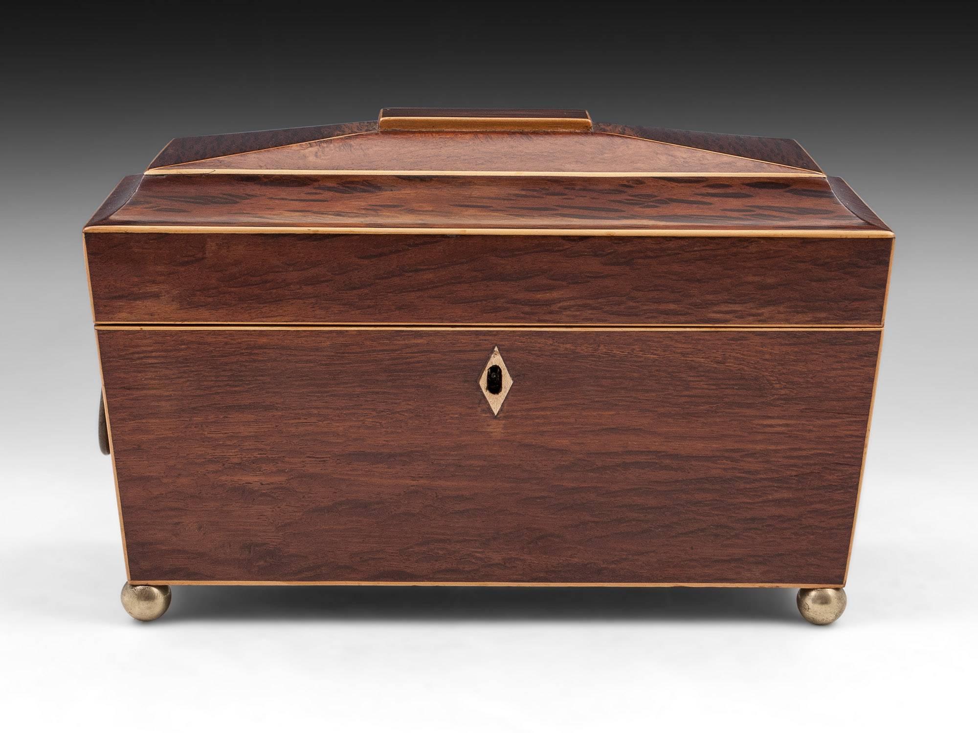 Antique Regency Partridgewood tea chest with boxwood edging, press brass handles and solid brass ball feet.

The interior has a plain glass mixing bowl and two removable tea caddies. 

This tea chest comes with a fully working lock and tasselled