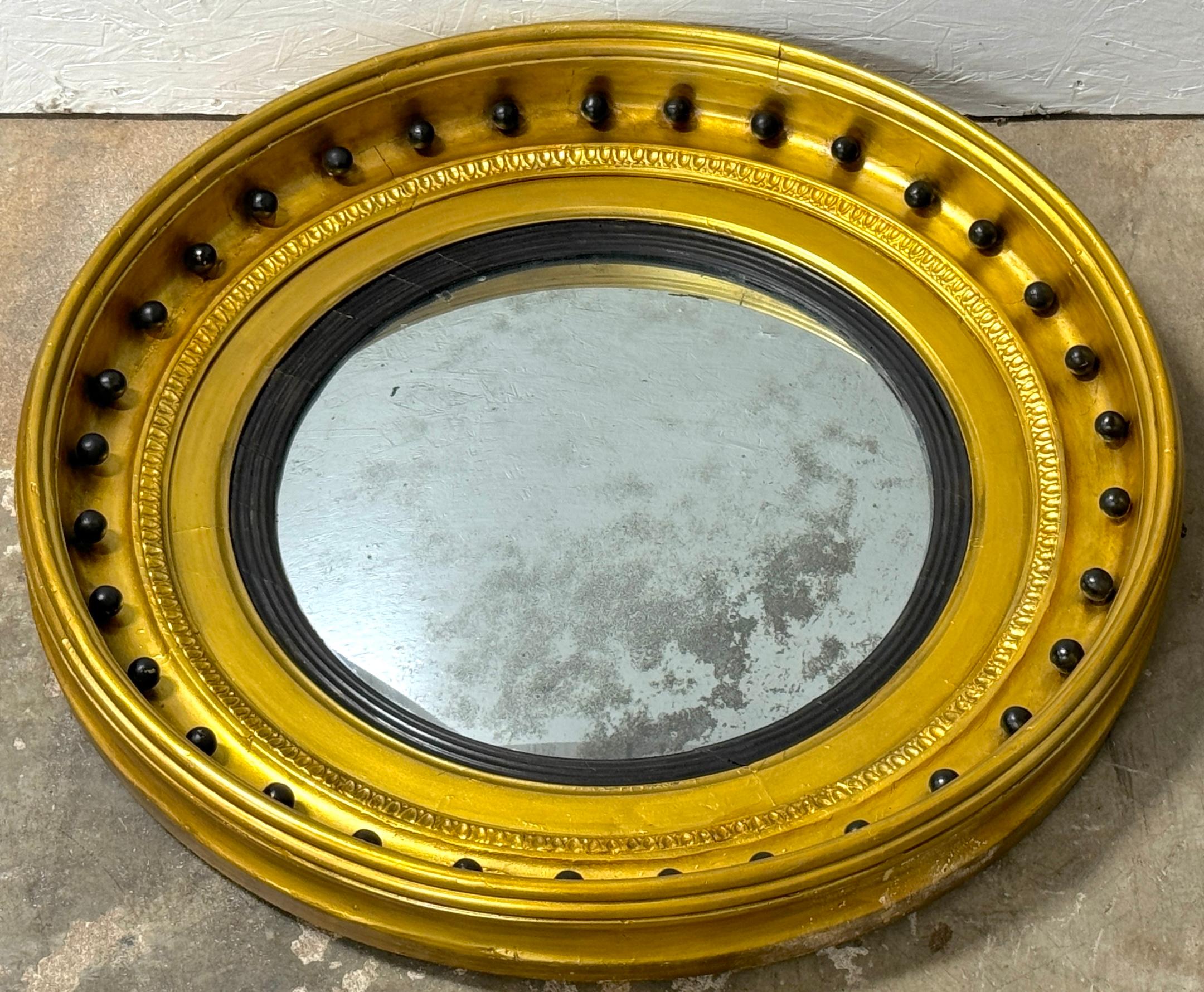 Antique Regency Period Giltwood, Gesso, and Ebonized Convex Mirror
England, circa 1820

Originating from England circa 1820, this exquisite antique Regency period convex mirror embodies the elegance and sophistication of the era. Measuring 29 inches