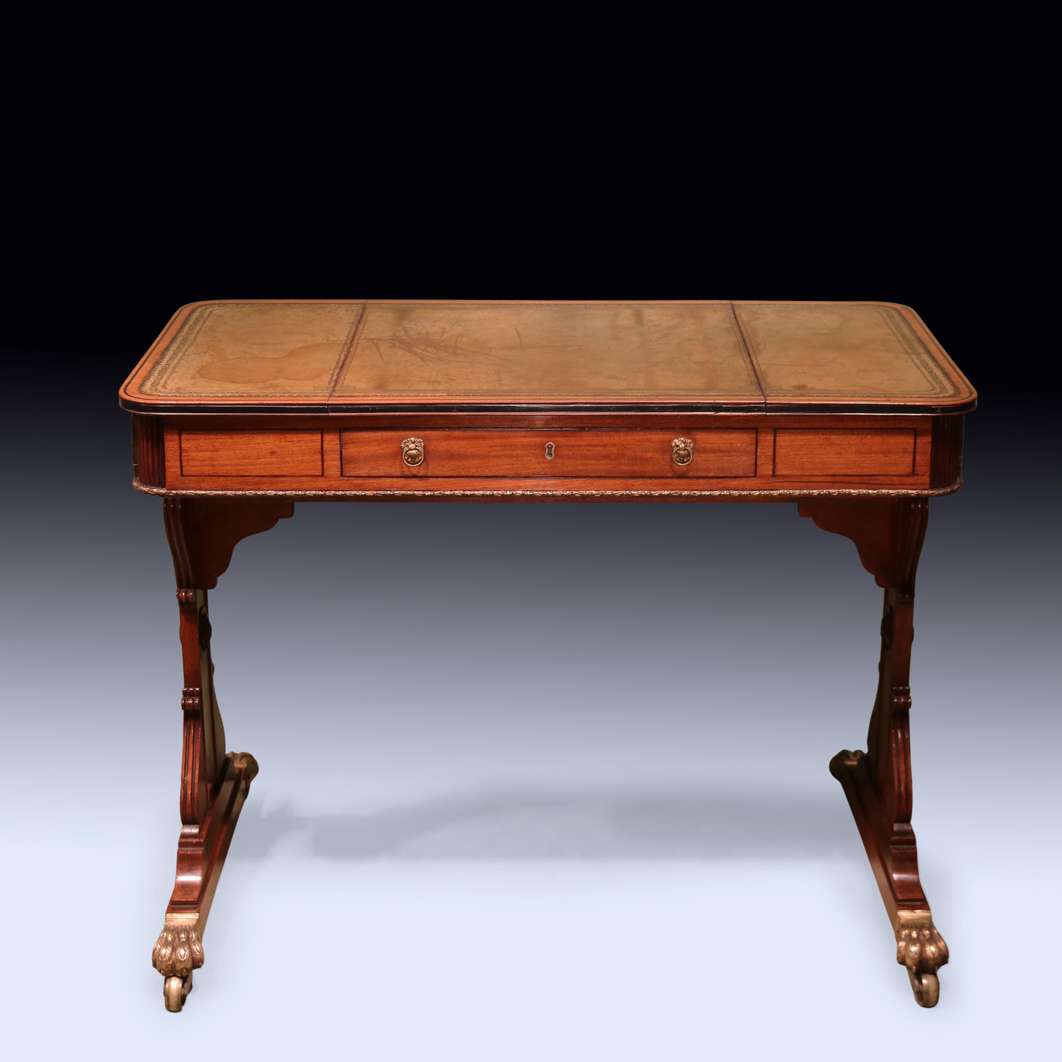 Tavolino da scrittura in mogano del periodo Regency dei primi del XIX secolo, di piccole proporzioni, intarsiato in ebano, con piano in pelle verde lavorata a stampo e carrello da scrittura sollevabile.  Il tavolo, con 3 cassetti a fregio, è