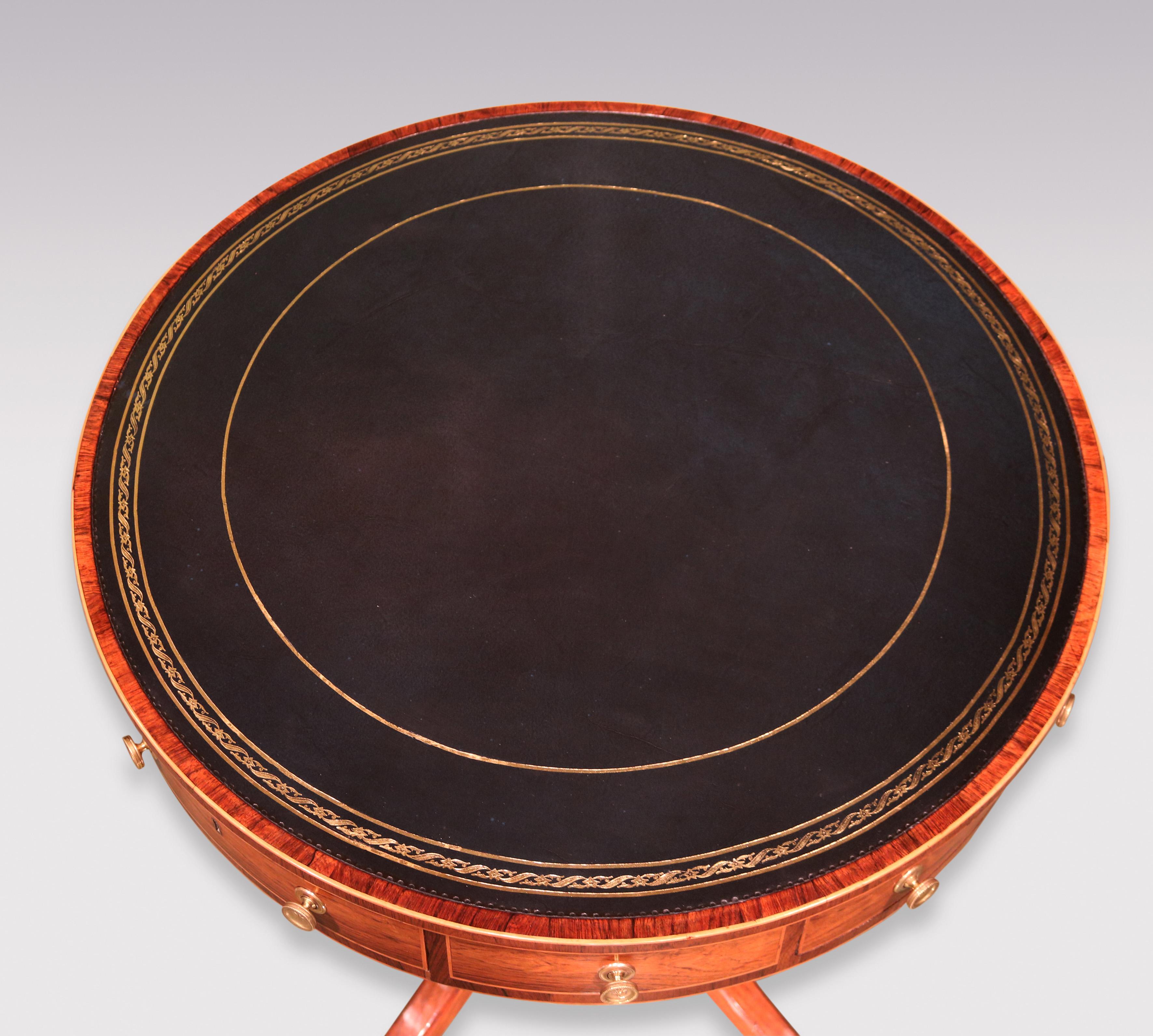 An elegant George III period rosewood Drum Table of attractive small proportions, boxwood strung throughout, having gilt-tooled dark blue leather circular top above 4 opening & 4 dummy drawers, supported on turned gunbarrel stem raised on 4