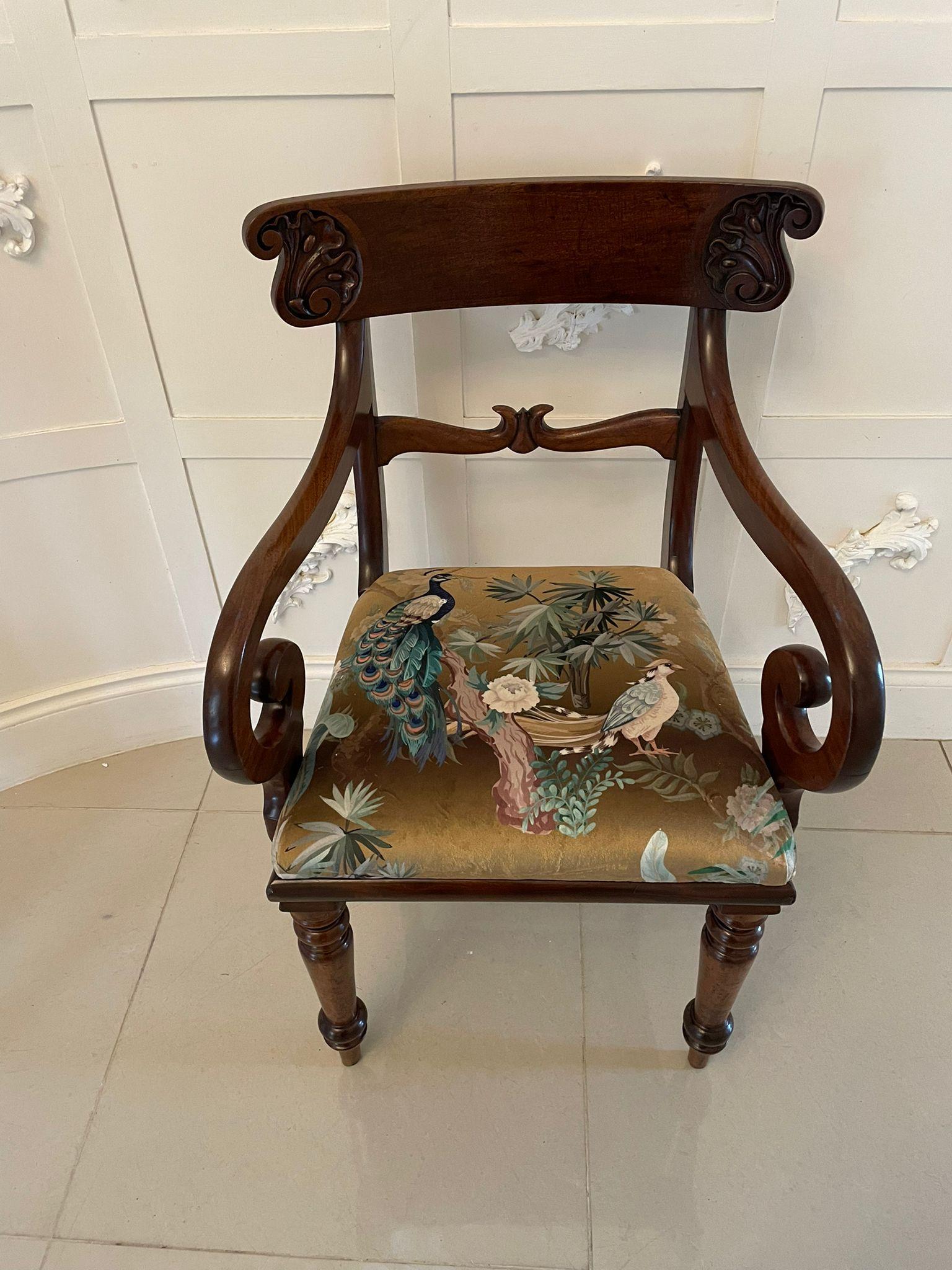 Antique Regency quality mahogany desk chair having a quality carved mahogany top rail, shaped carved mahogany centre splat, scroll shaped open arms, newly reupholstered drop in seat in a quality fabric standing on shaped turned tapering legs to the
