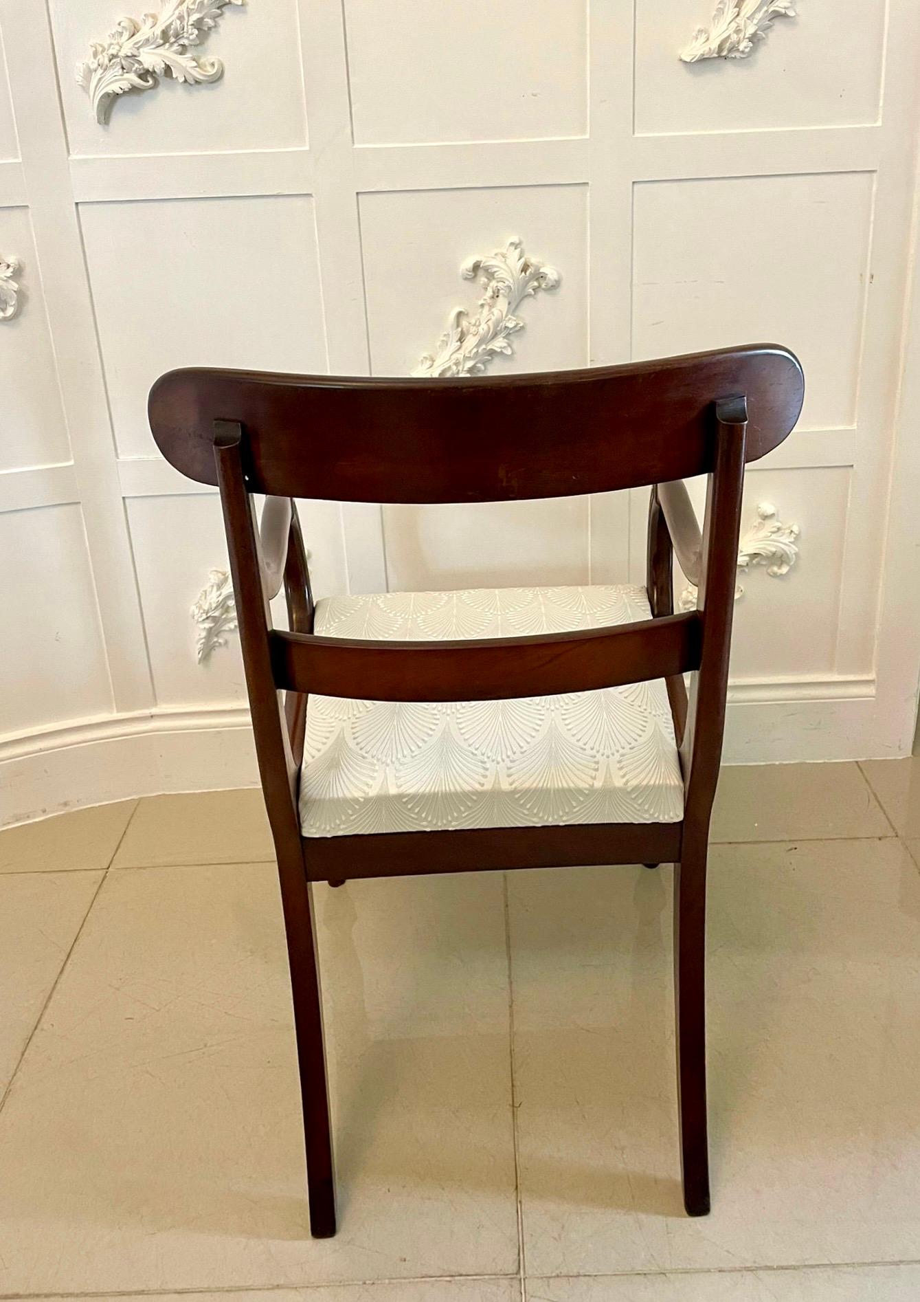Antique Regency quality mahogany desk chair having a quality figured mahogany top rail and centre splat, elegant carved mahogany shaped open arm, newly reupholstered drop in seat in a quality fabric standing on turned tapering legs to the front and