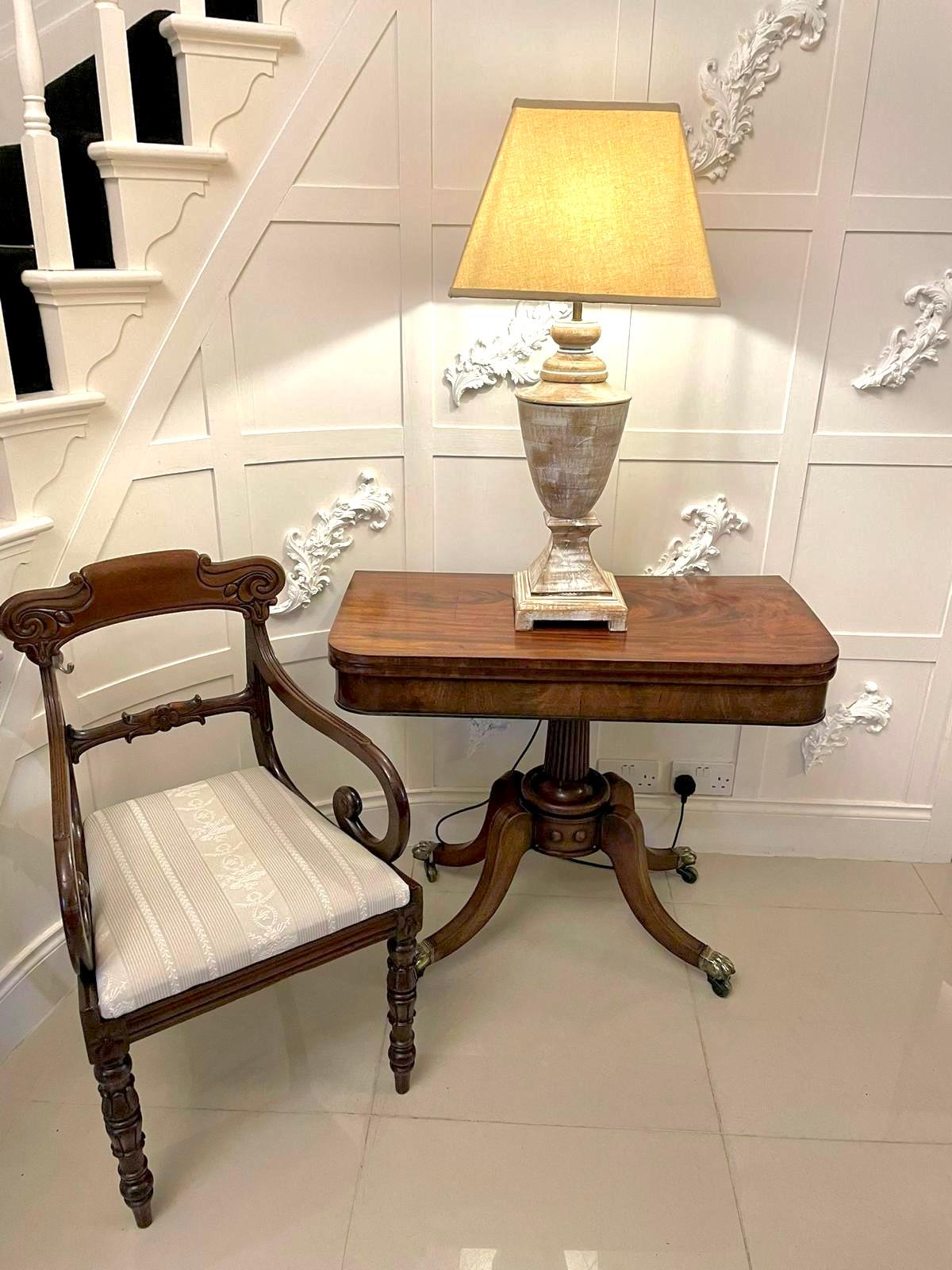 Antique Regency quality mahogany fold over card table having a quality figured mahogany fold over top opening to reveal a green baize interior, mahogany shaped frieze supported by a reeded column on a circular platform with four elegant shaped