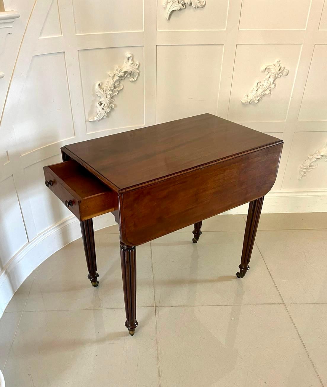 Antique regency quality mahogany Pembroke table having a quality mahogany top with two drop leaves and a molded edge above one working drawer and a dummy drawer with original turned mahogany knobs. It stands on elegant reeded tapering legs with