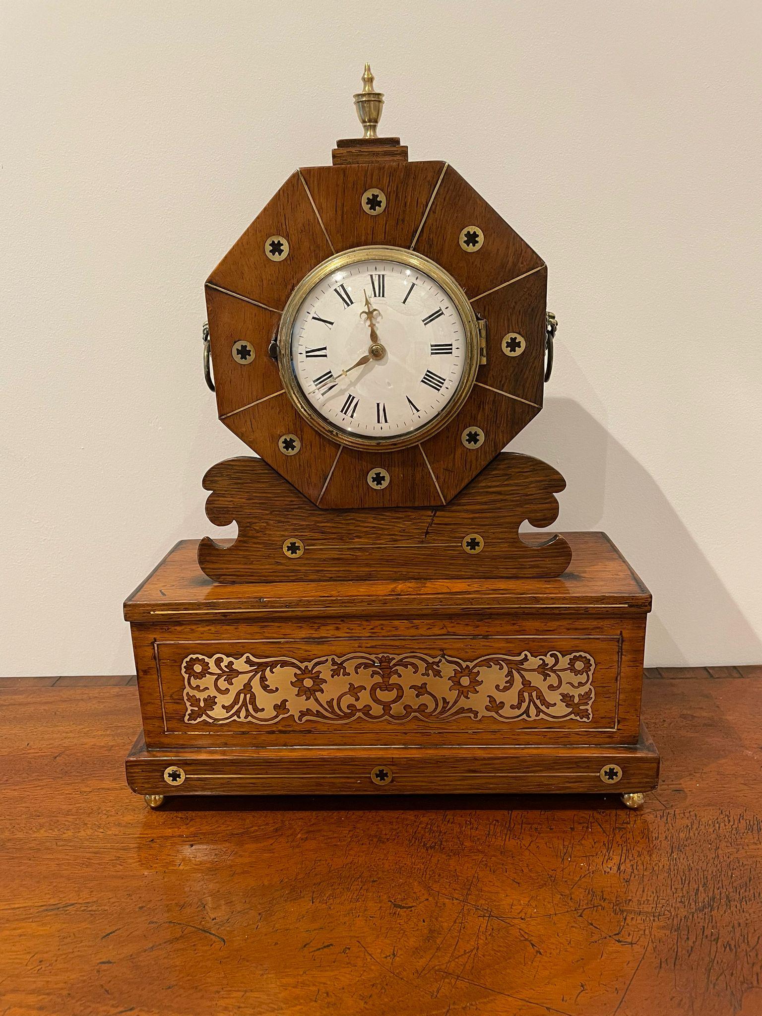 Antique Regency quality rosewood brass inlaid mantle clock having a quality rosewood brass inlaid case with a circular porcelain dial, original hands, 8 day movement, brass finale to the top, brass carrying handles to the sides and raised on