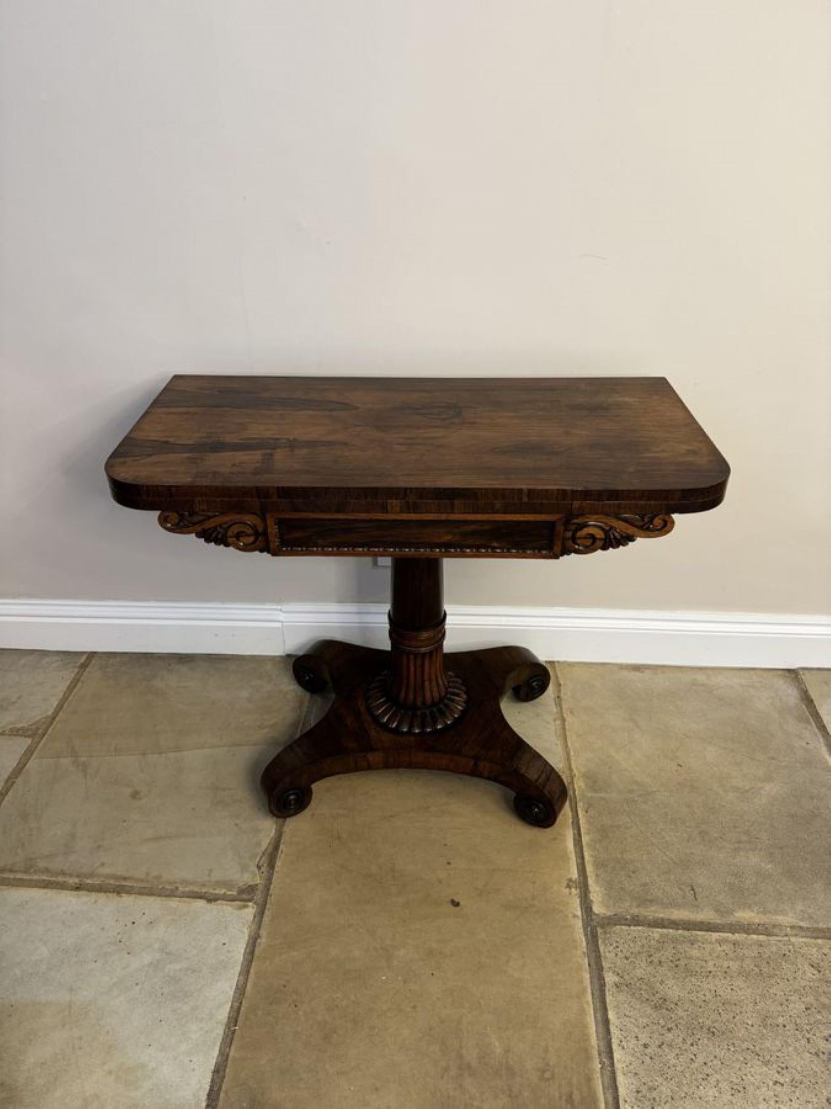 Antique Regency quality rosewood tea table, having a quality rosewood fold over top opening to reveal a polished interior, superb carved rosewood frieze supported on a turned carved reeded pedestal column, standing on a platform base with scroll
