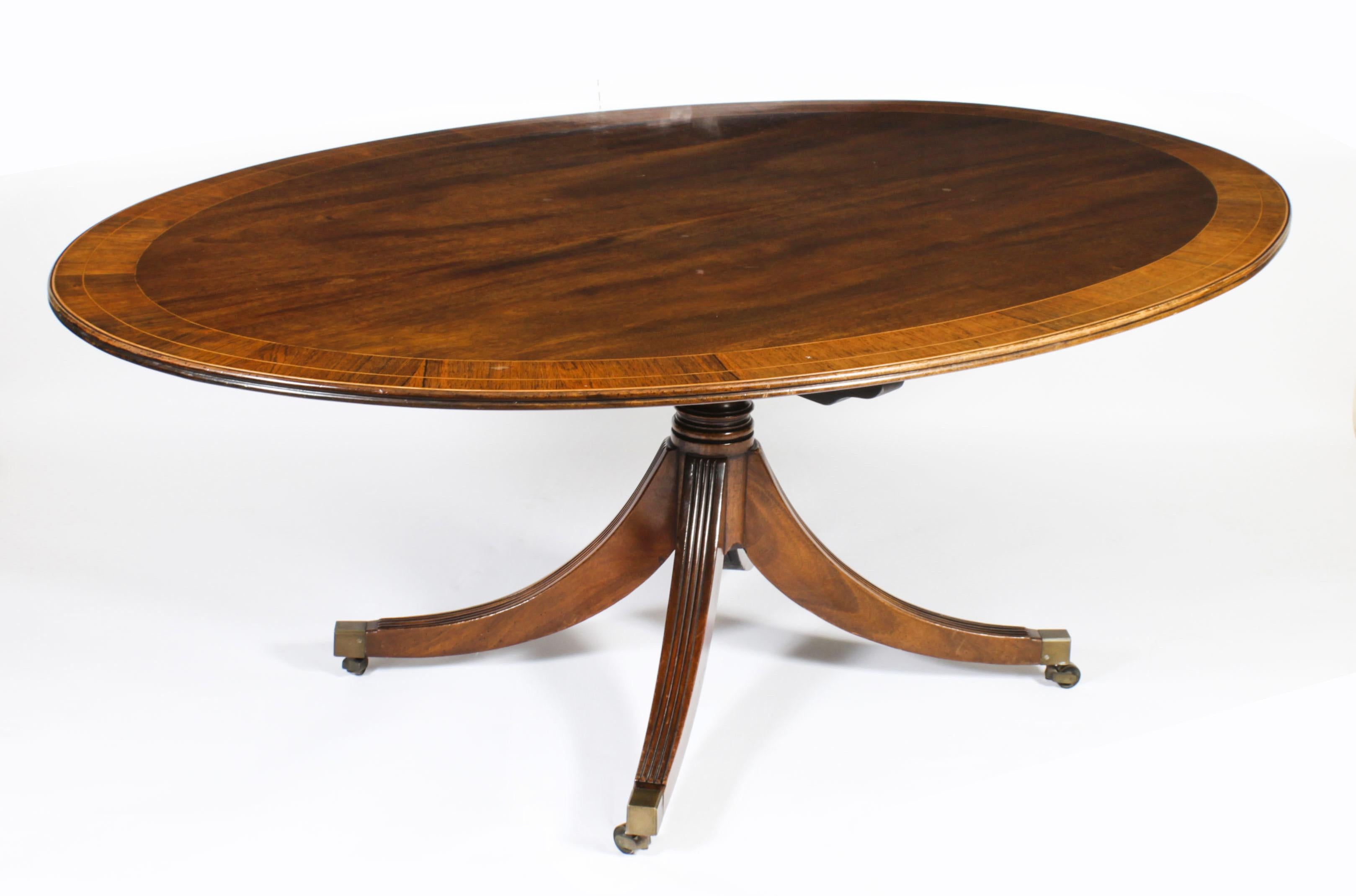 This is a beautiful antique Regency Revival flame mahogany and Gonçalo Alves banded tilt top oval dining table dating from Circa 1920, with a matching set of eight Regency Revival Barback dining chairs. 

The fabulous 6ft 6inch flame mahogany tilt