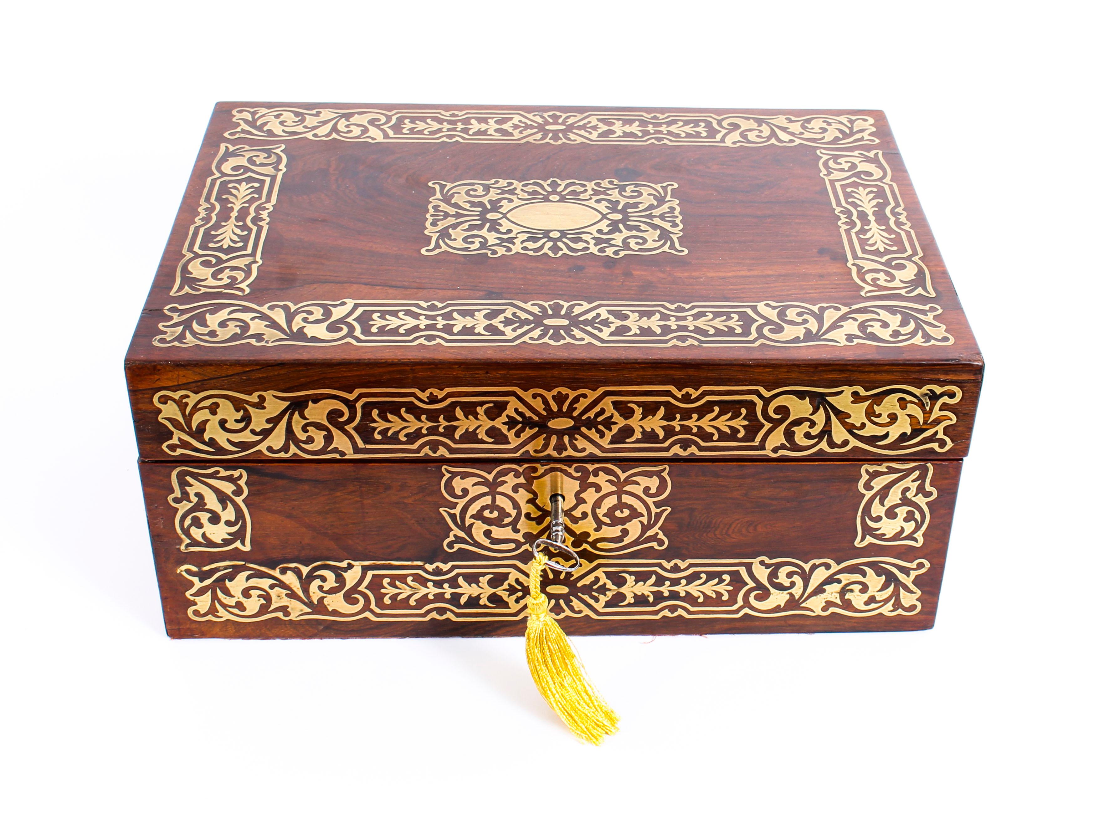 This is a highly decorative antique Regency rosewood and brass inlaid writing and stationery slope of rectangular shape, circa 1820 in date.

The box is profusely inlaid with decorative brass foliate scrollwork decoration and features recessed