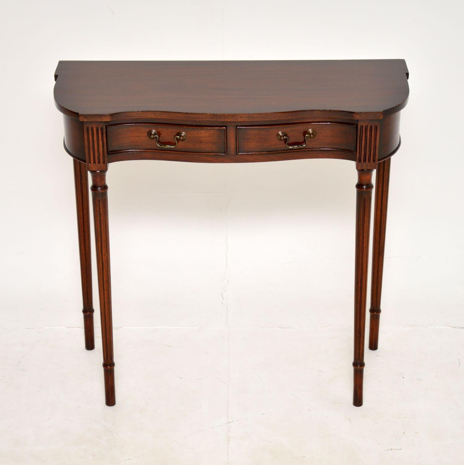 A beautiful and elegant wood console table in the antique Regency style. This was made in England, it dates from around the 1950’s period.

The quality is excellent and this has a lovely, compact and stylish design. The front has a serpentine