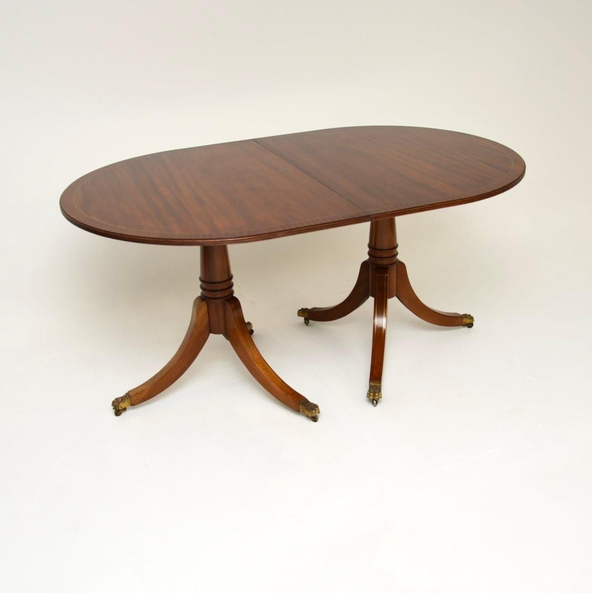 Un delizioso tavolo da pranzo allungabile in ottone intarsiato in stile Regency. Prodotto in Inghilterra, risale agli anni '1930 circa.

Ha un bellissimo piano con bordi in ottone intarsiato. Ogni metà poggia su una base a treppiede con gambe