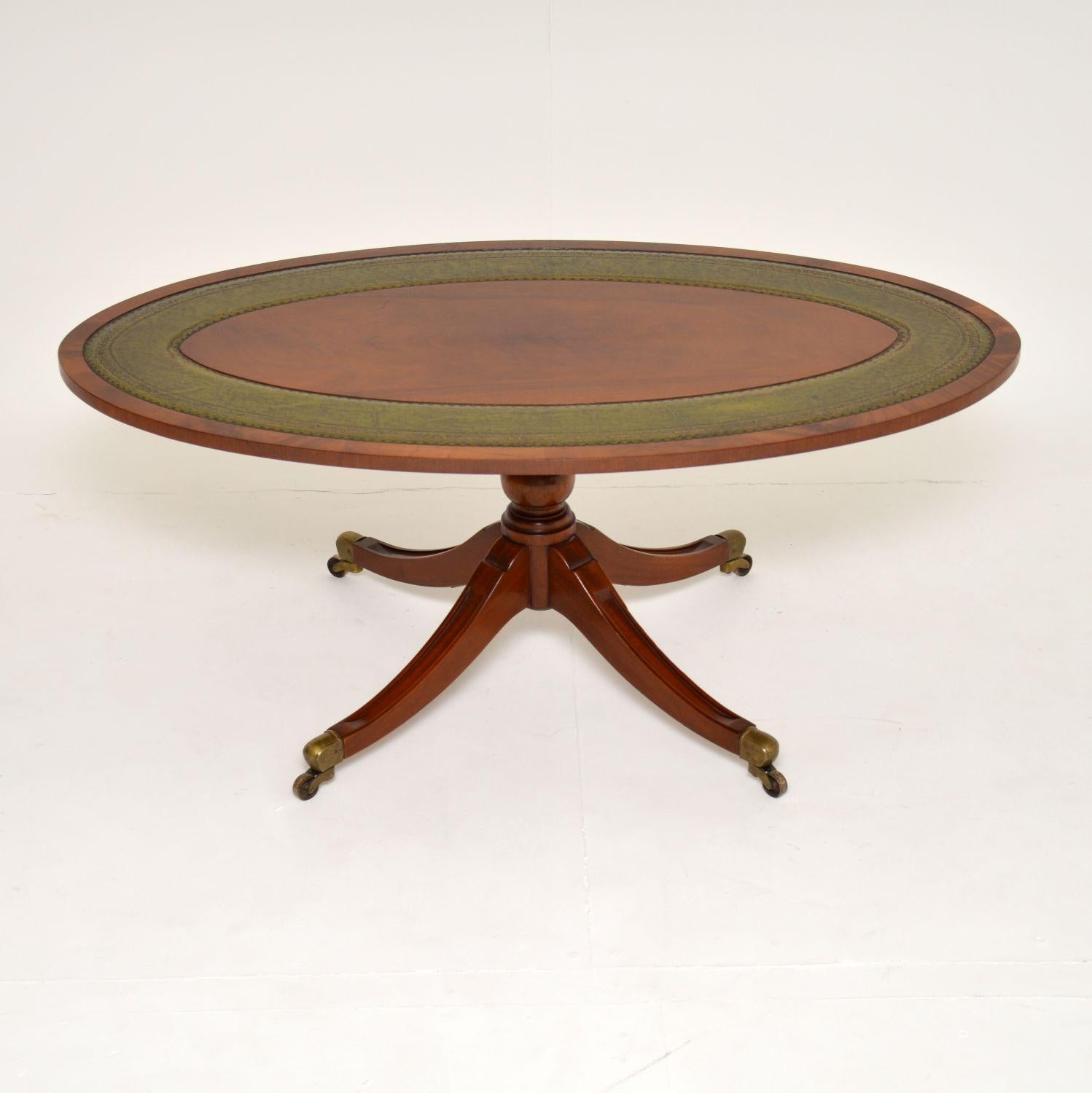A beautifully made antique Regency style coffee table in wood and leather. This was made in England, it dates from around the 1950’s.

The quality is excellent, this is a great size. The oval top has inset tooled green leather. It sits on a
