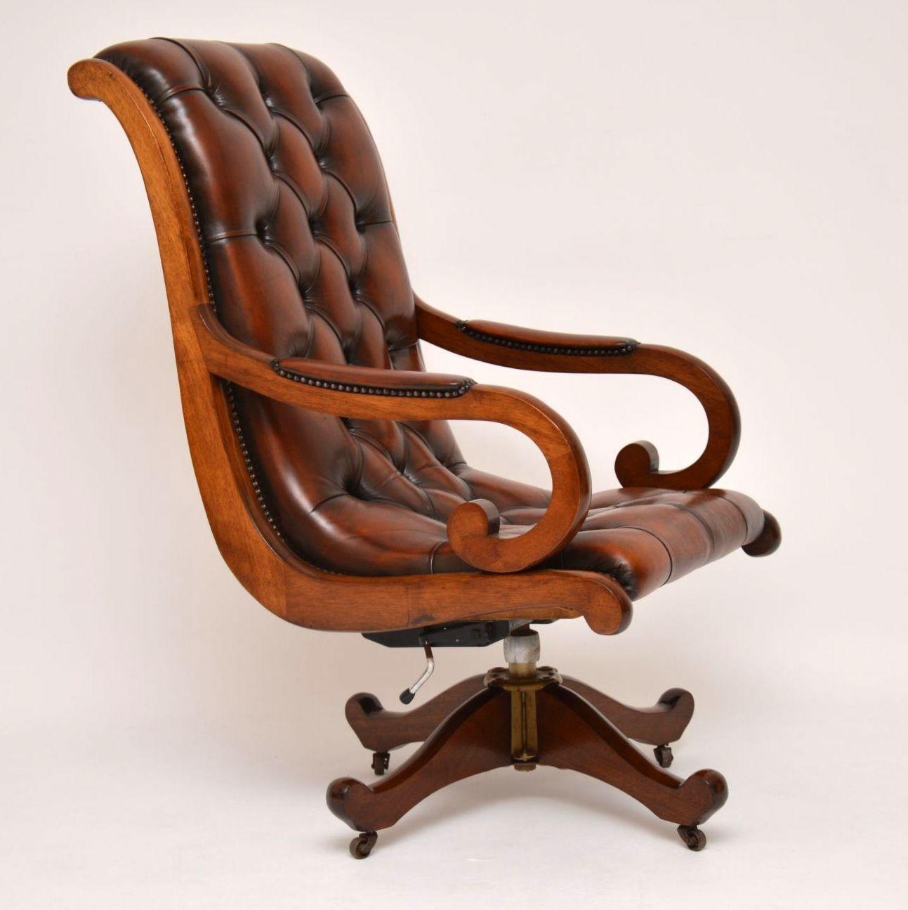 Antique Regency style mahogany swivel desk armchair upholstered in deep buttoned brown leather hand tacked onto the frame. Not only does it swivel, but it tilts back and can be adjusted in height. This is a very comfortable chair with good back
