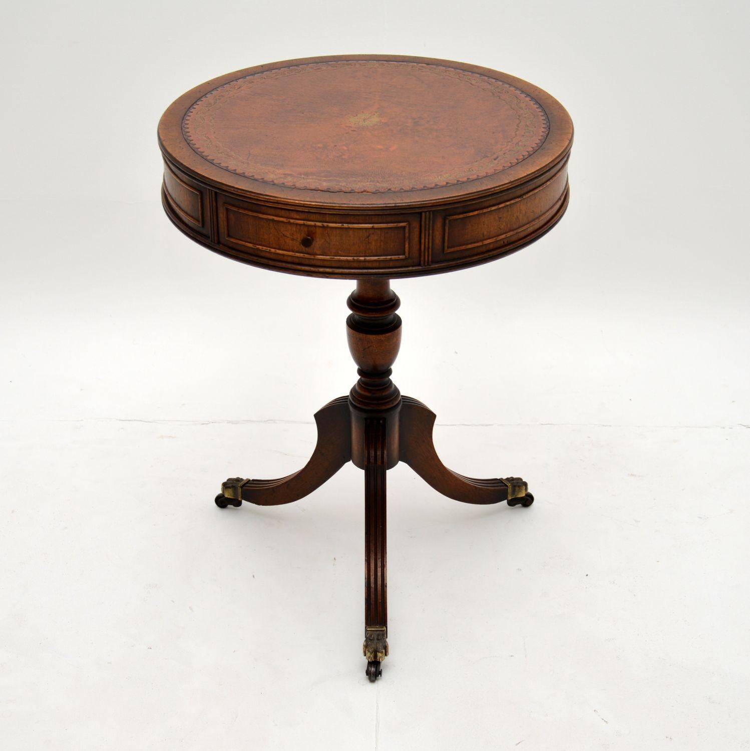 A beautiful drum table in the antique Regency style, which I would date from around the 1930-50’s period.

It is very well made and is a useful size. The brown leather top is beautifully gold tooled, this has brass handles on the two drawers and