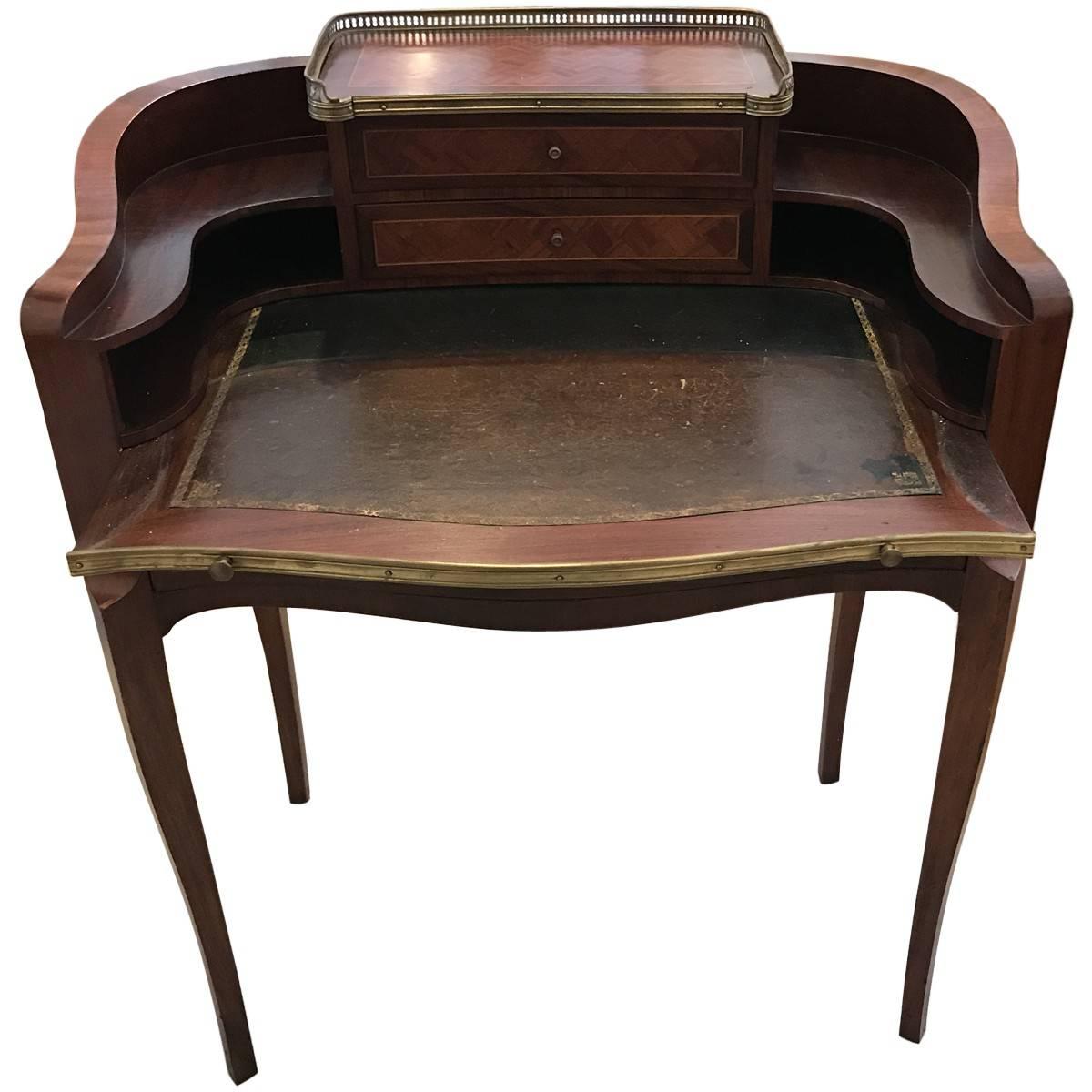 A collectible piece from bygone days, featuring the finest craftsmanship, materials, and design elements of its given era. Rich and elegant, this dapper writing desk is crafted from flamed mahogany and features a leather top inlay. Three drawers