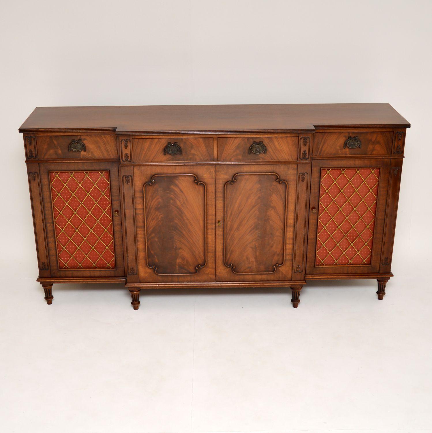 A very impressive antique Regency style grill front sideboard in mahogany. This dates from circa 1950s.

It is of outstanding quality, with stunning flame mahogany veneers and beautifully moulded mahogany borders on the doors. The brass grill