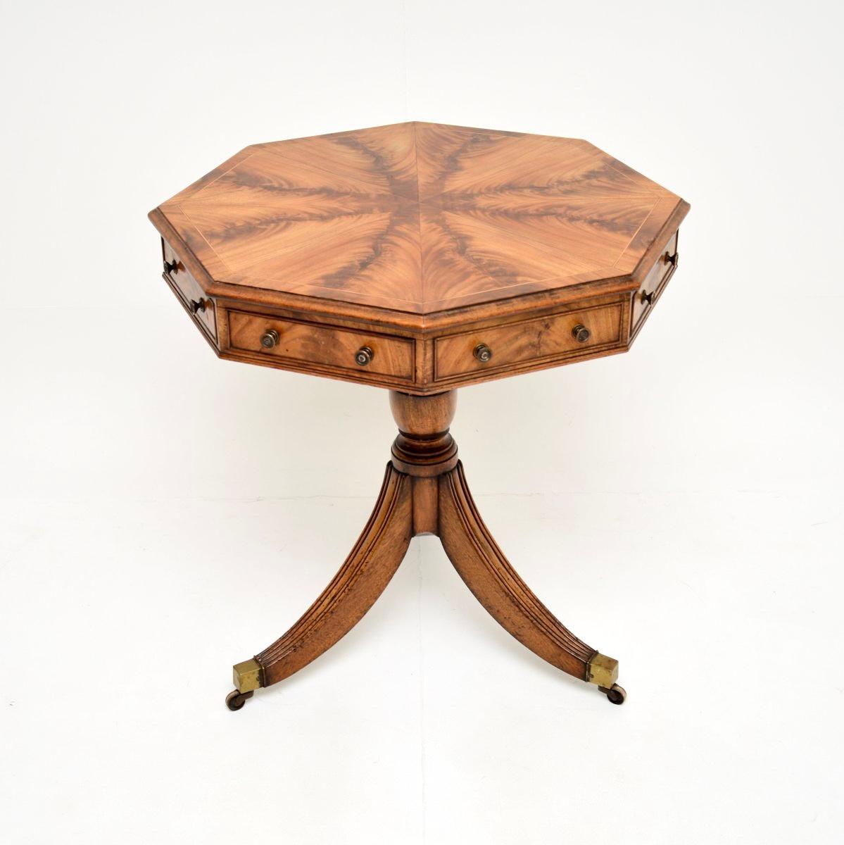 A stunning antique octagonal drum table, made in England, and dating from around the 1900-1910 period.

This is of outstanding quality, the top is segmented with the most beautiful flamed grain patterns. There are four drawers with brass handles and