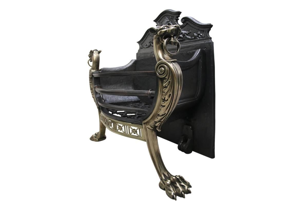 Mid Victorian dog grate in the Regency style supported by bronze wolfhounds with rings in their mouths, and on clawed feet, the brass apron is bowed and pierced. Dated 1884.
