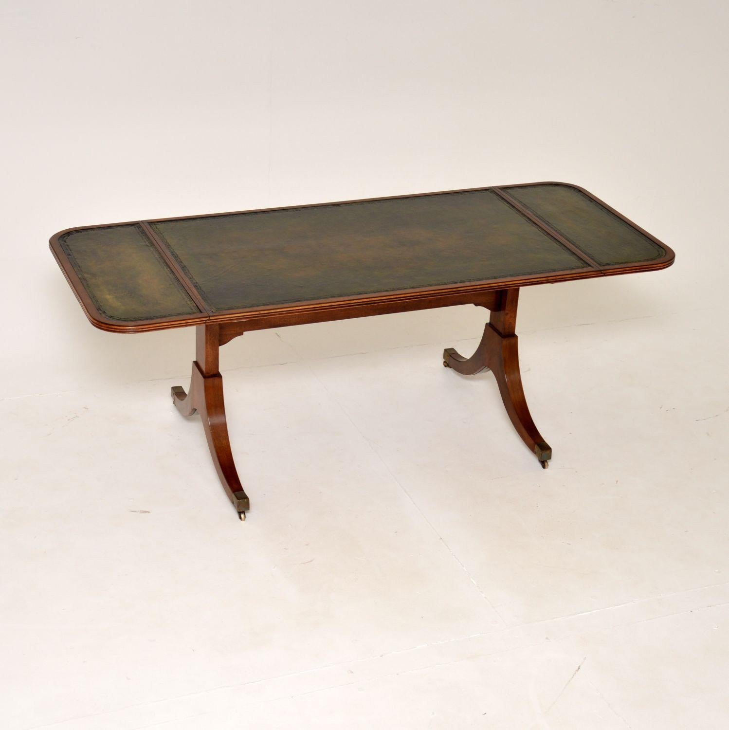 A lovely antique Regency style drop leaf coffee table in wood and leather. This was made in England, it dates from around the 1930’s.

It has a stylish and useful design, the drop down ends lift up and are supported with pull out rails to increase