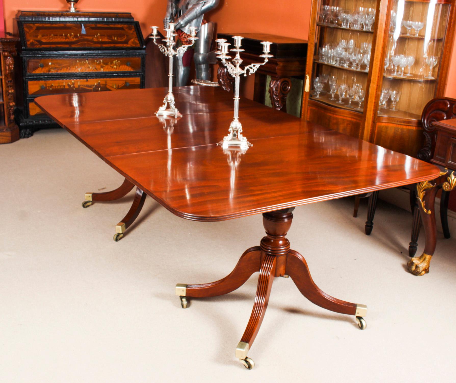 This is an elegant antique Regency Period Mahogany dining table, Circa 1820 in date.
 
The table is of rectangular form with rounded corners and reeded edge. It is raised on twin baluster column supports with four reeded legs ending in brass caps