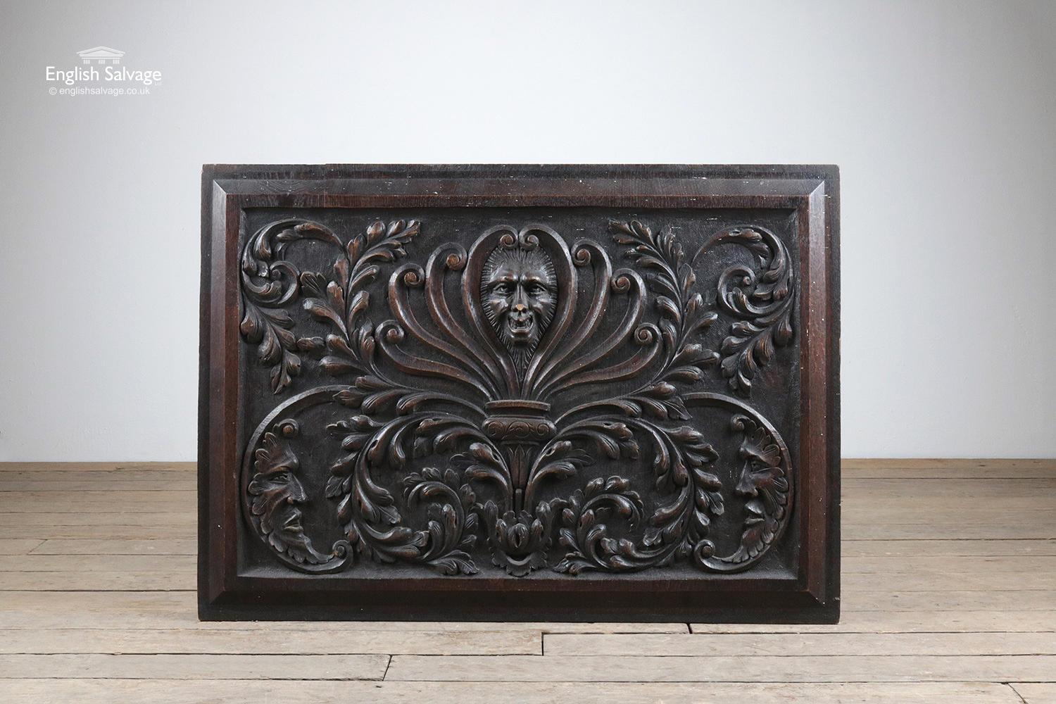 This salvaged oak panel is relief carved with ornate detailing of central mask positioned in an anthemion surrounded by foliate scrolls and two further masks in the bottom two corners of the rectangular panel. The panel has some minor scratches and