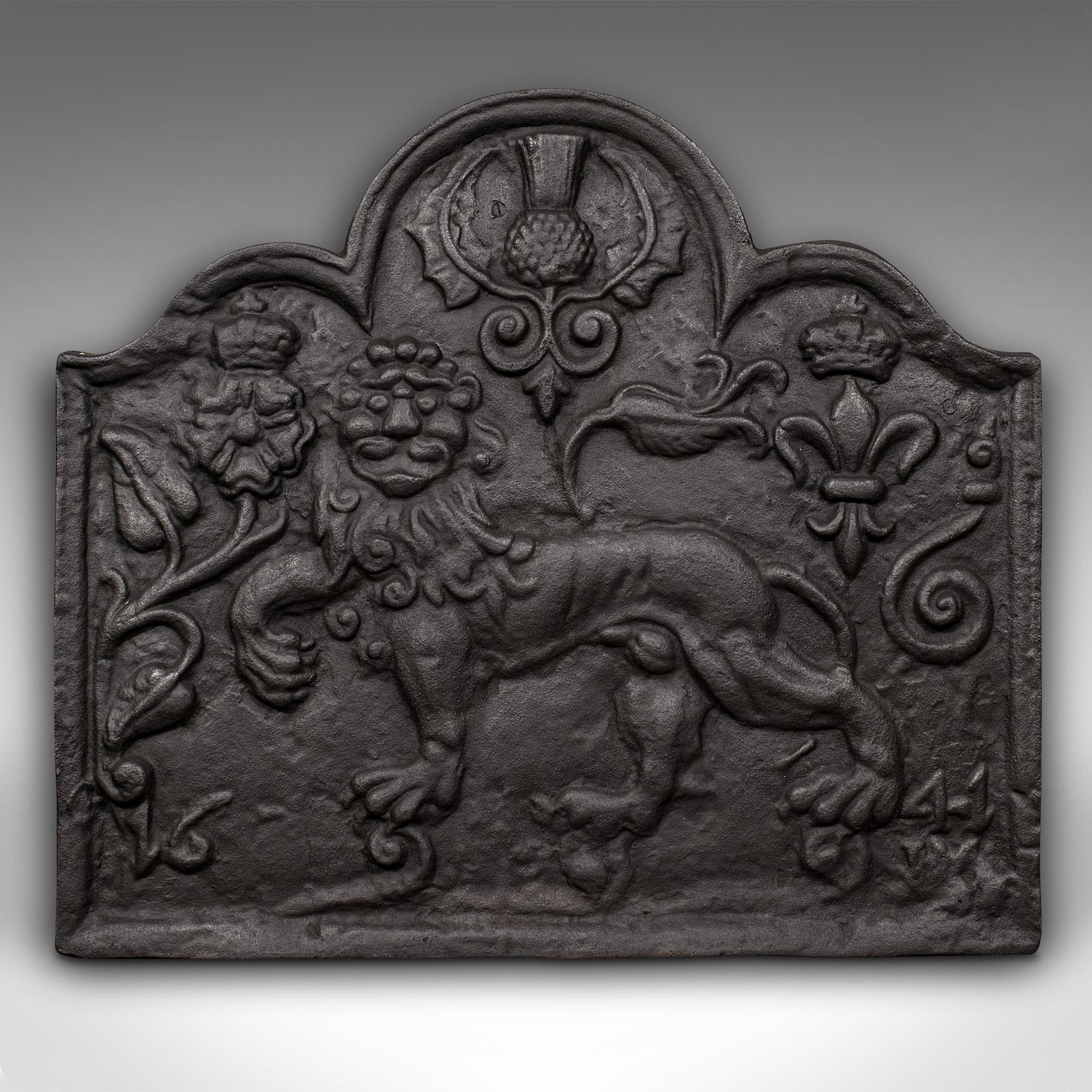 This is an antique relief fire back. An English, cast iron decorative fireplace reflector with Carolean taste, dating to the late Victorian period, circa 1900.

Charmingly ornate cast fire back with superb lion motif.
Displays a desirable aged