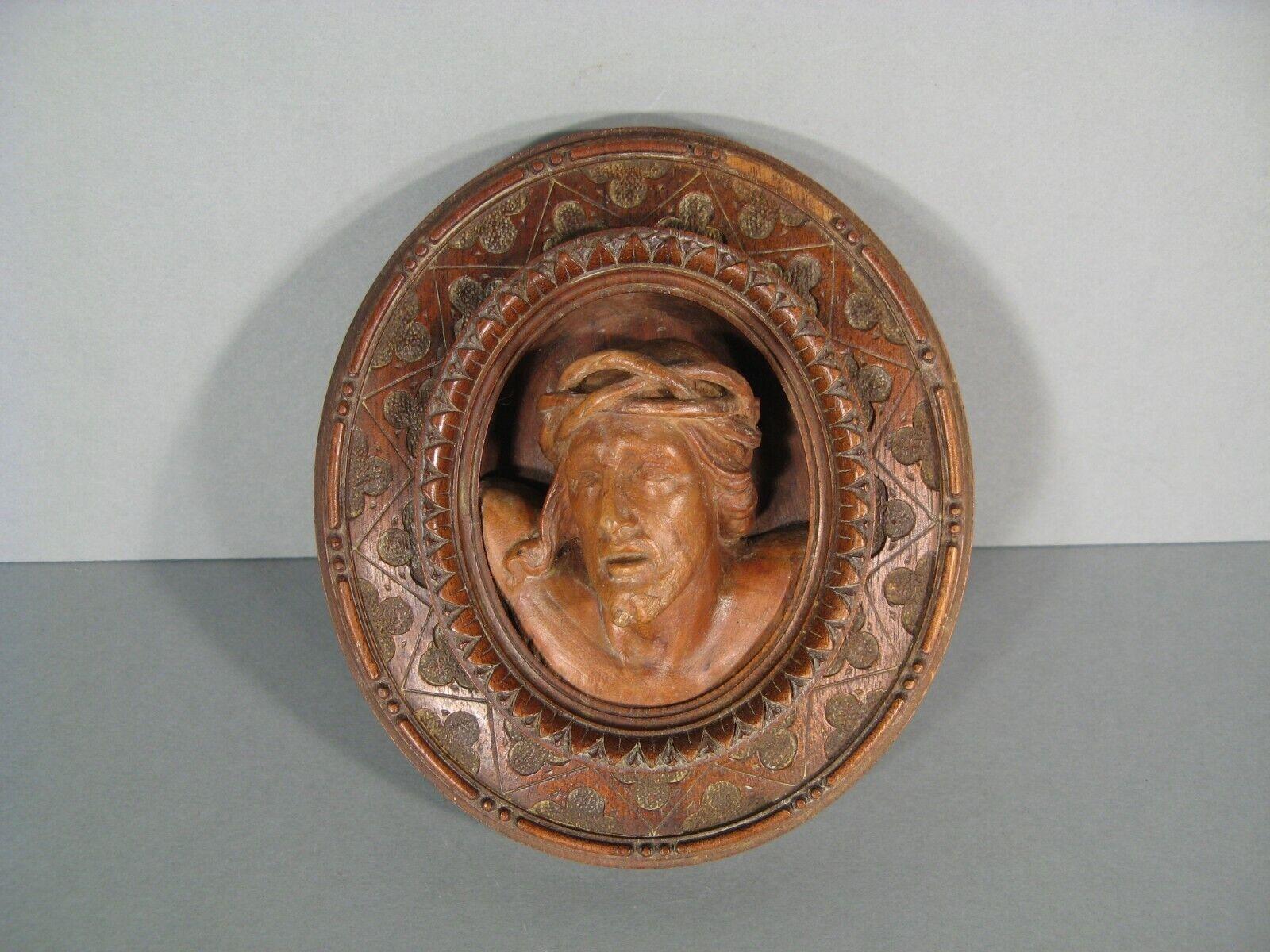 Introduce a piece of profound religious artistry into your home with this antique oval medallion featuring a detailed depiction of Christ with a crown of thorns. Crafted from sculpted and patinated wood, this medallion carries a poignant inscription