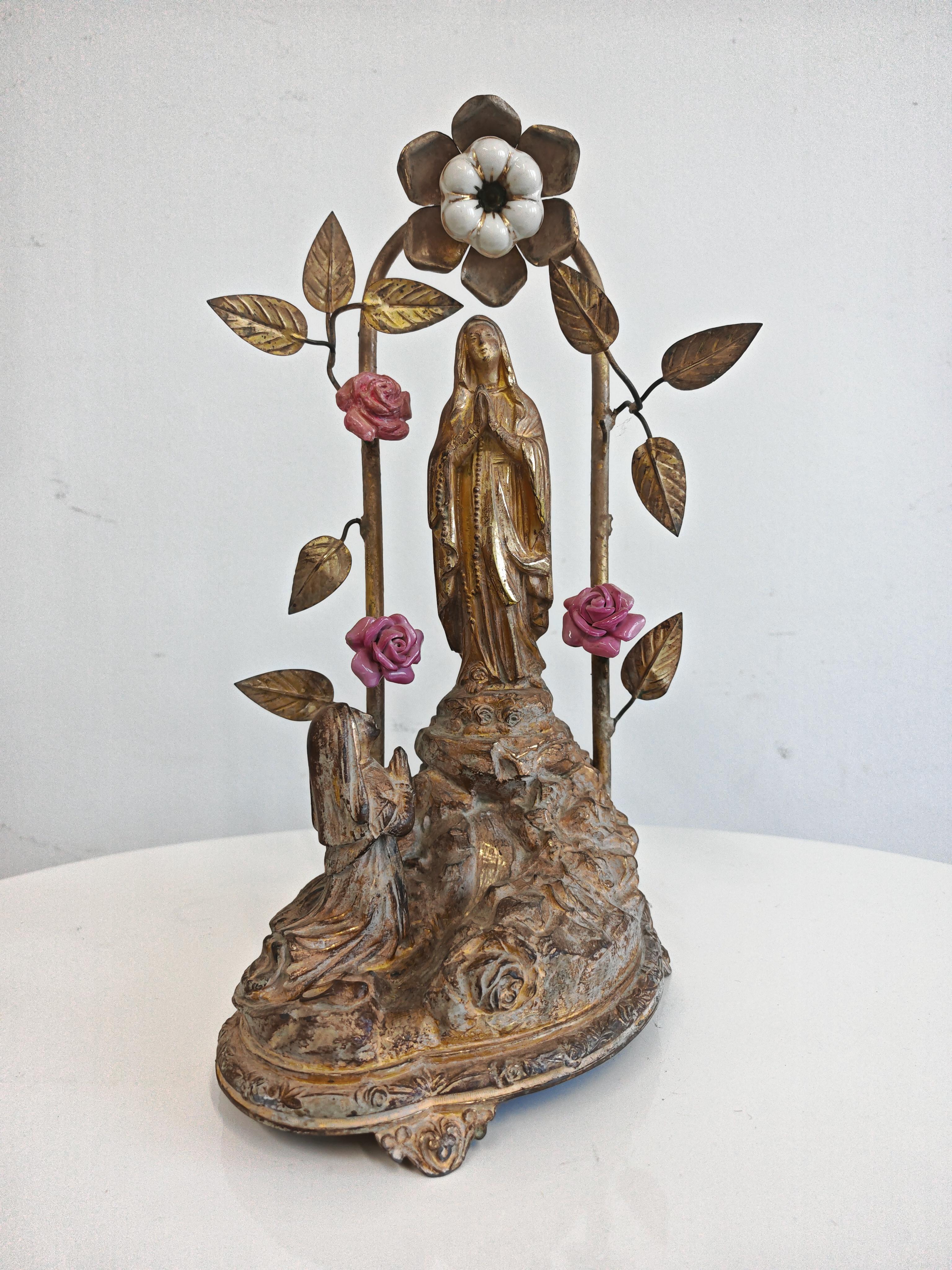Dans cette annonce, vous trouverez un rare souvenir religieux en bronze de Lourdes, représentant la Vierge Marie. La pièce est réalisée en bronze. Qui semble avoir été plaqué or. Un souvenir de Notre-Dame de Lourdes présente trois roses en