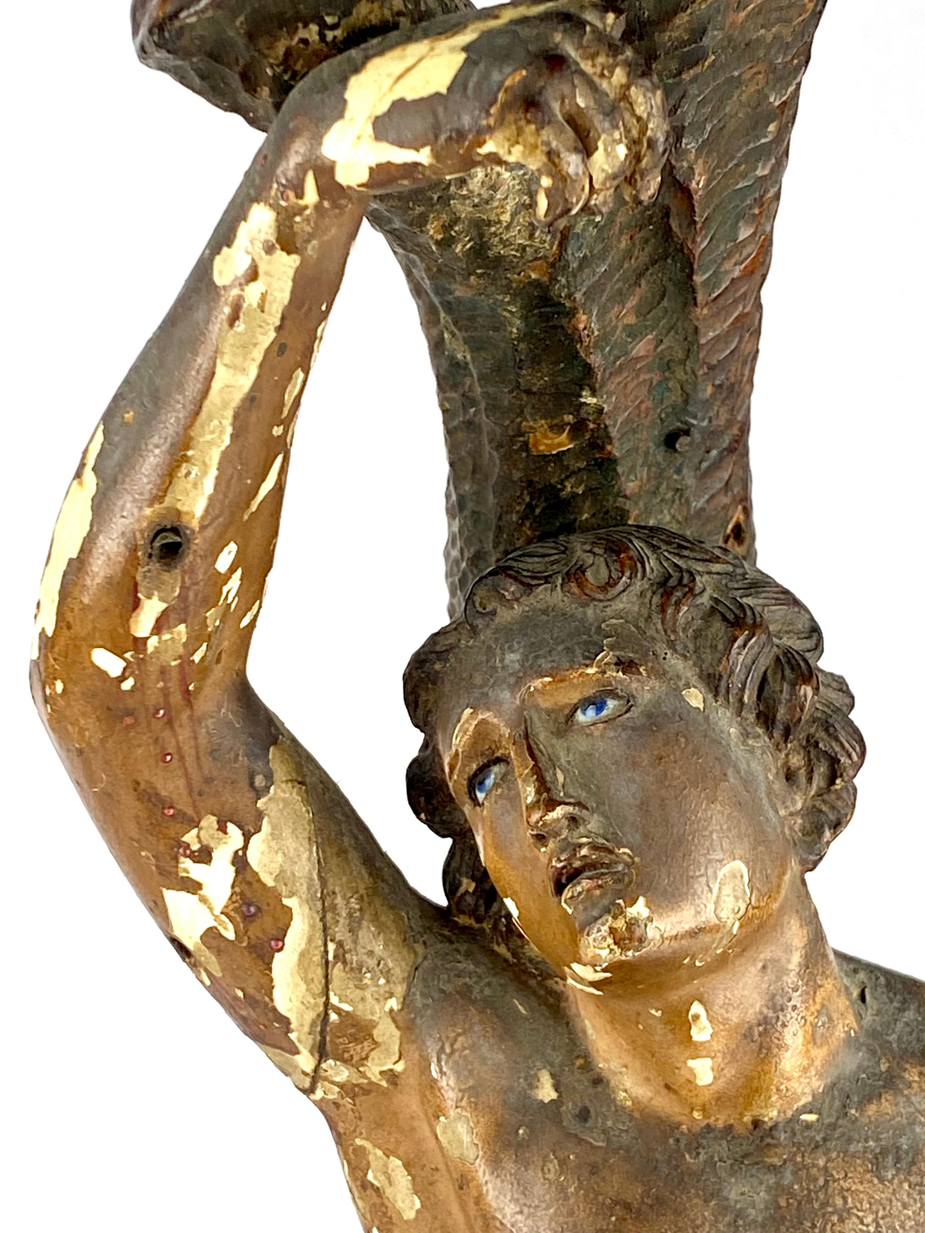 An Antique Religious Statue of Saint Sebastian mid 19th Century Portugal with blue Glass Eyes
Circa 1850
The beads of blood on his legs are rubies 
Some loss to the Polychrome painting and he is missing 1 finger and 1 thumb
Height 44.5 cm