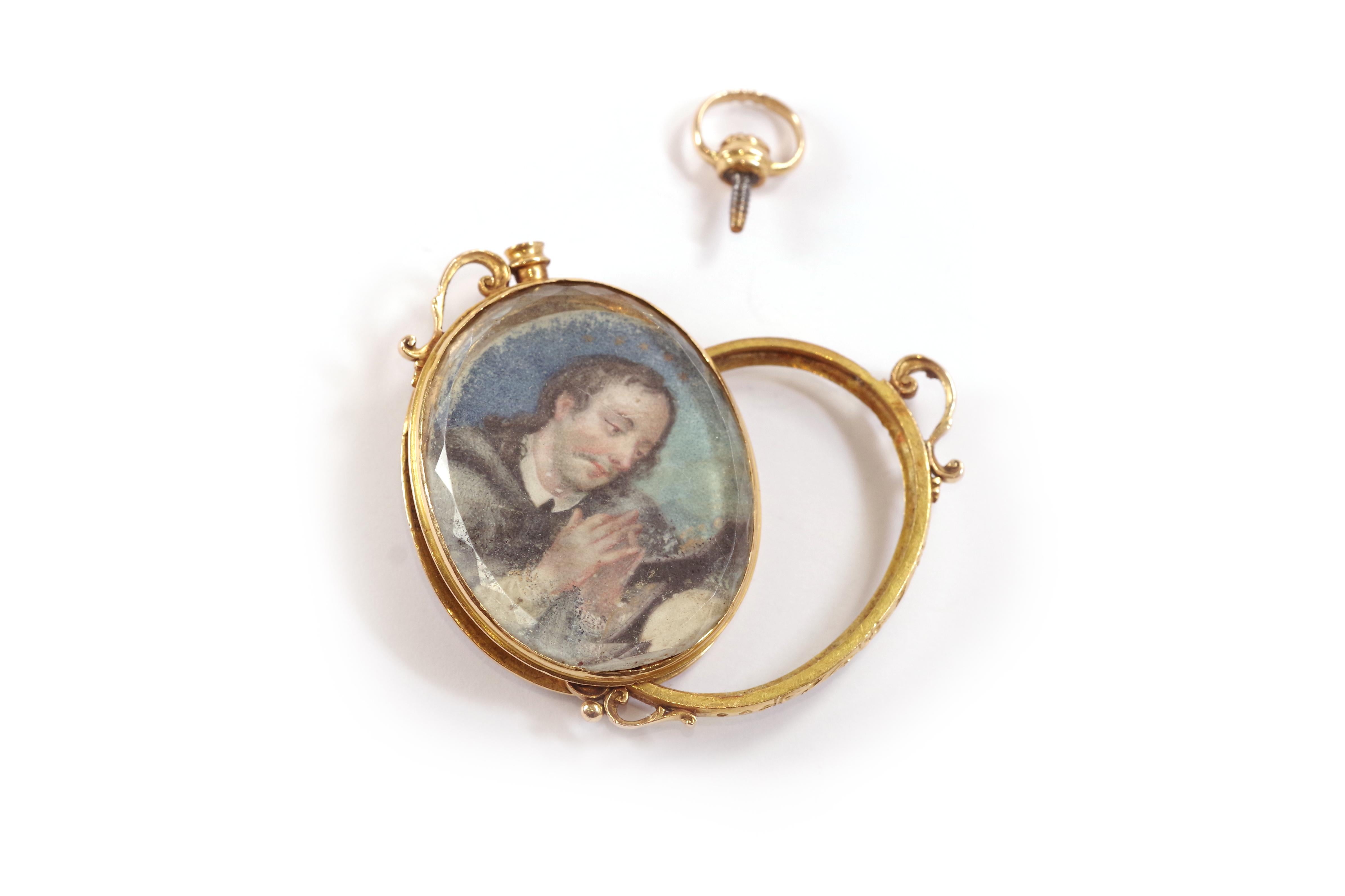 Antique reliquary locket pendant in 18k rose gold. On one side, the pendant is decorated with a miniature on paper depicting Saint Jerome praying before a cross, with a skull in the foreground. The miniature is protected by a beveled oval glass. The