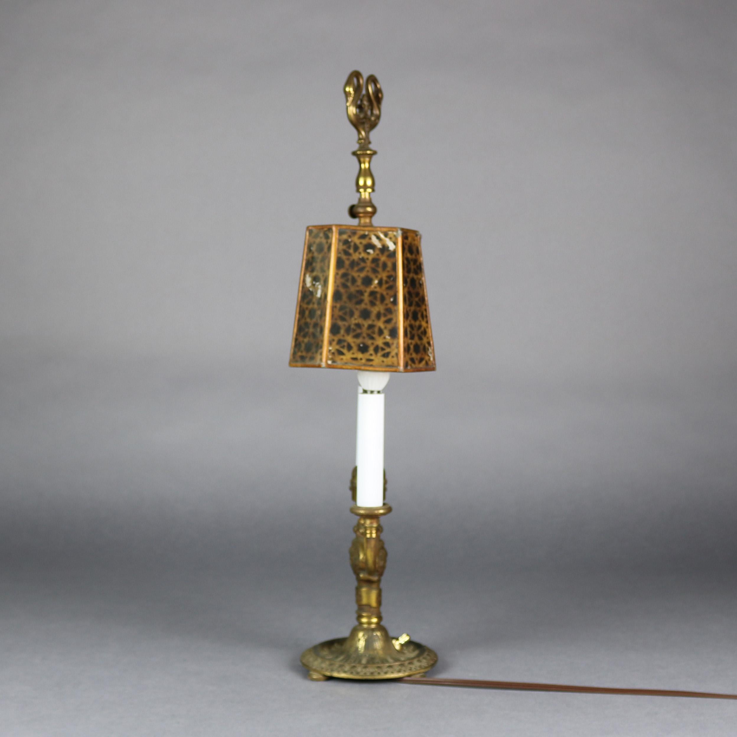 Antique Bouillotte table or desk lamp by Rembrandt features Bouillotte table lamp figural bast with column having mask flanked by two C-scroll arms terminating in candle lights, mica shade with swan form finial, gilt and ebonized shade reminiscent