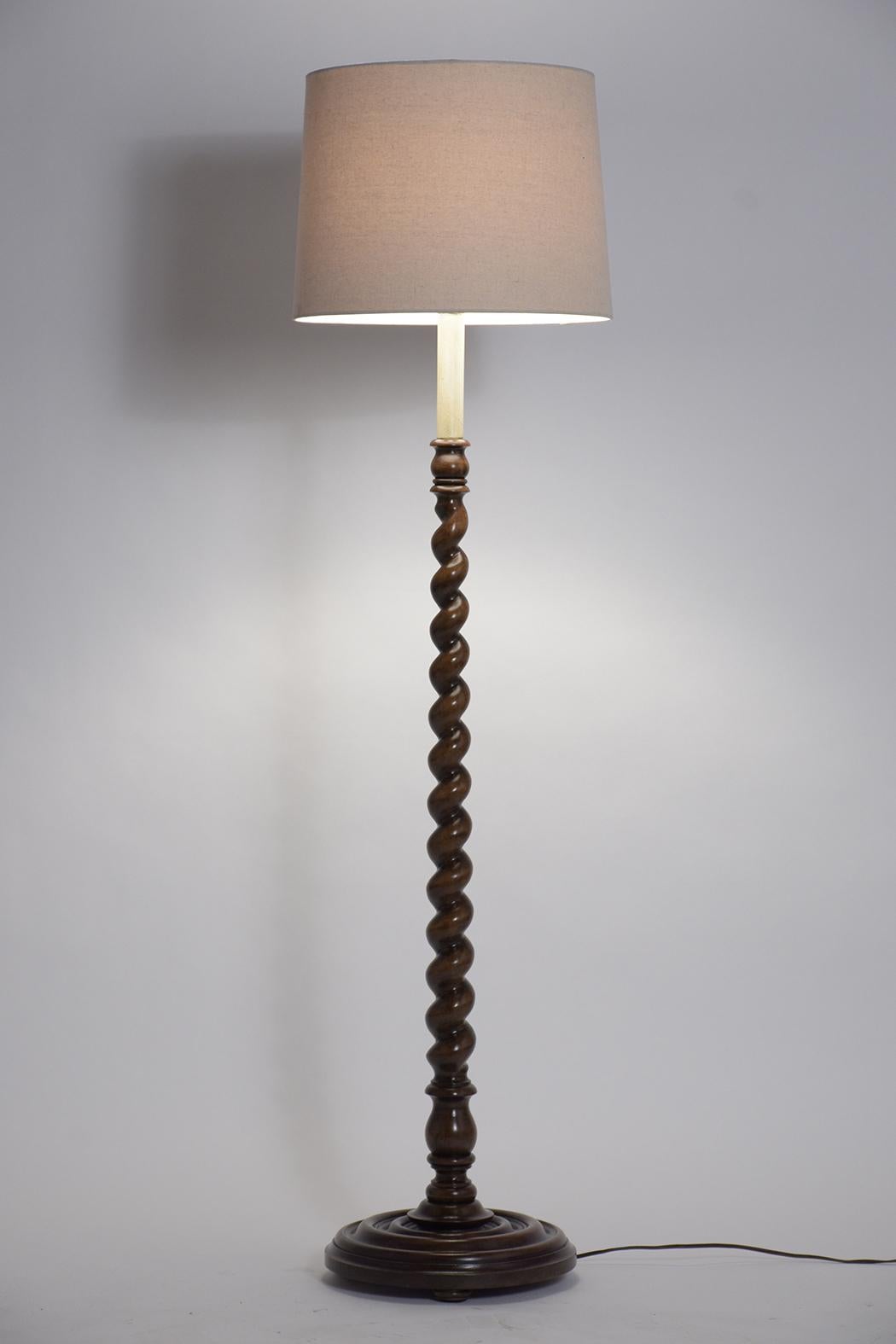 A fabulous French 19th century floor lamp handcrafted out of walnut wood. This lamp features finely carved details its original walnut finish, newly waxed and polished showing a beautiful patina finish. The lamp has a new shade and is wired to US