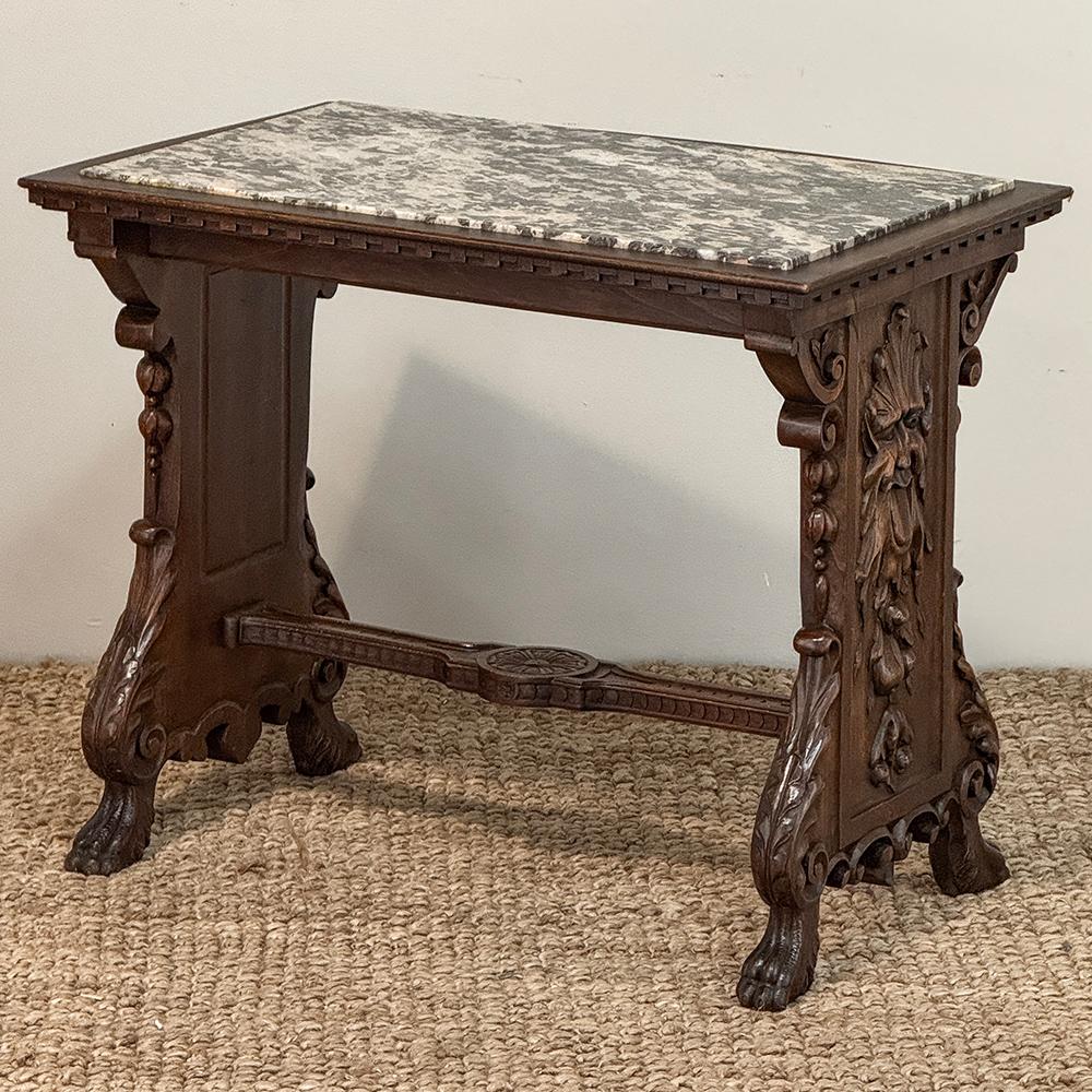 Cette table d'appoint en marbre de style Renaissance est ornée d'une créature forestière fantaisiste sur ses deux faces, qui sont également ornées d'une abondance de produits de la terre, encadrée par de somptueux rinceaux ondulants de feuilles
