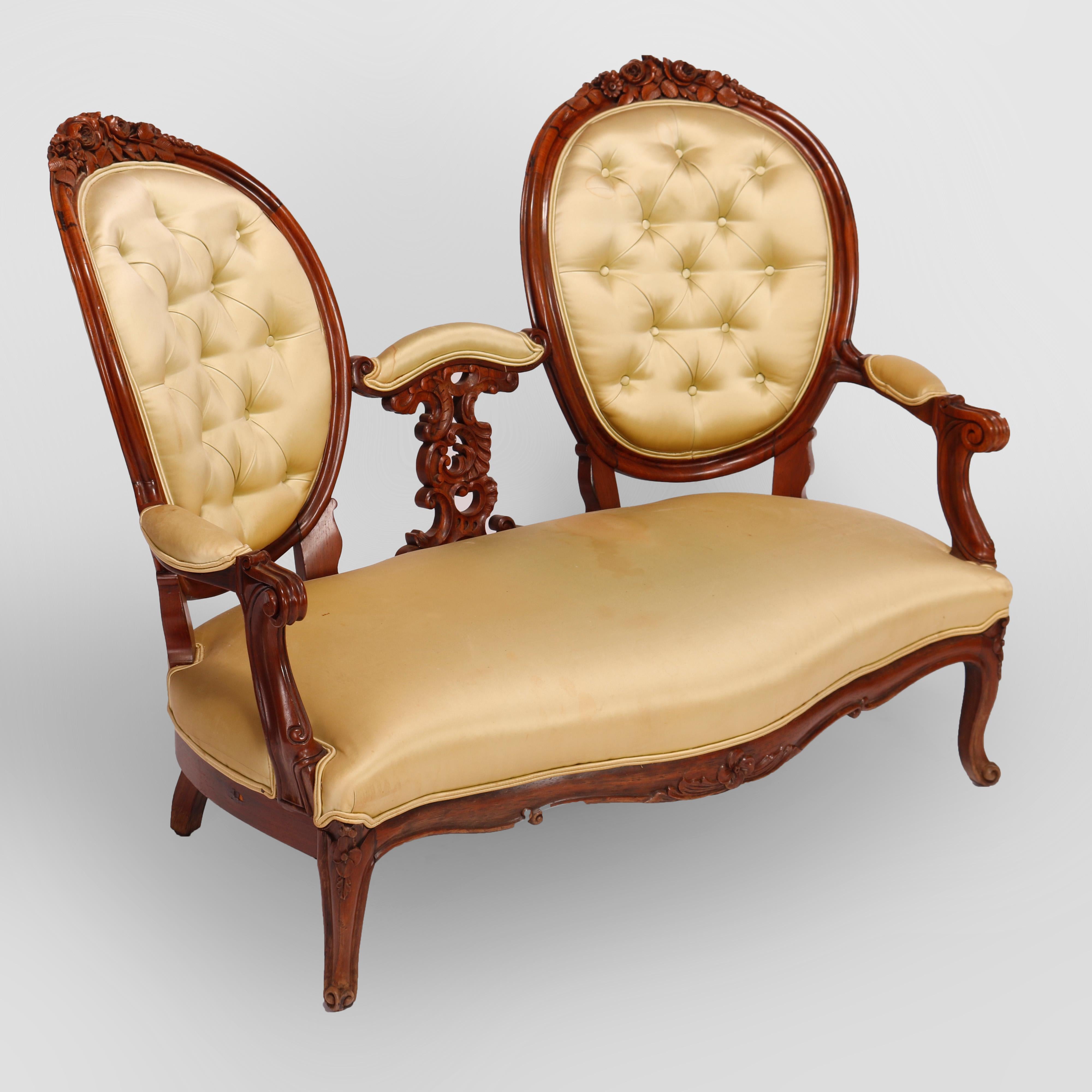 An antique Renaissance Revival settee offers rosewood construction with back having flanking tufted oval medallions with carved floral crests and carved gadroon element between, shaped serpentine seat, and raised on cabriole legs, c1880

Measures -