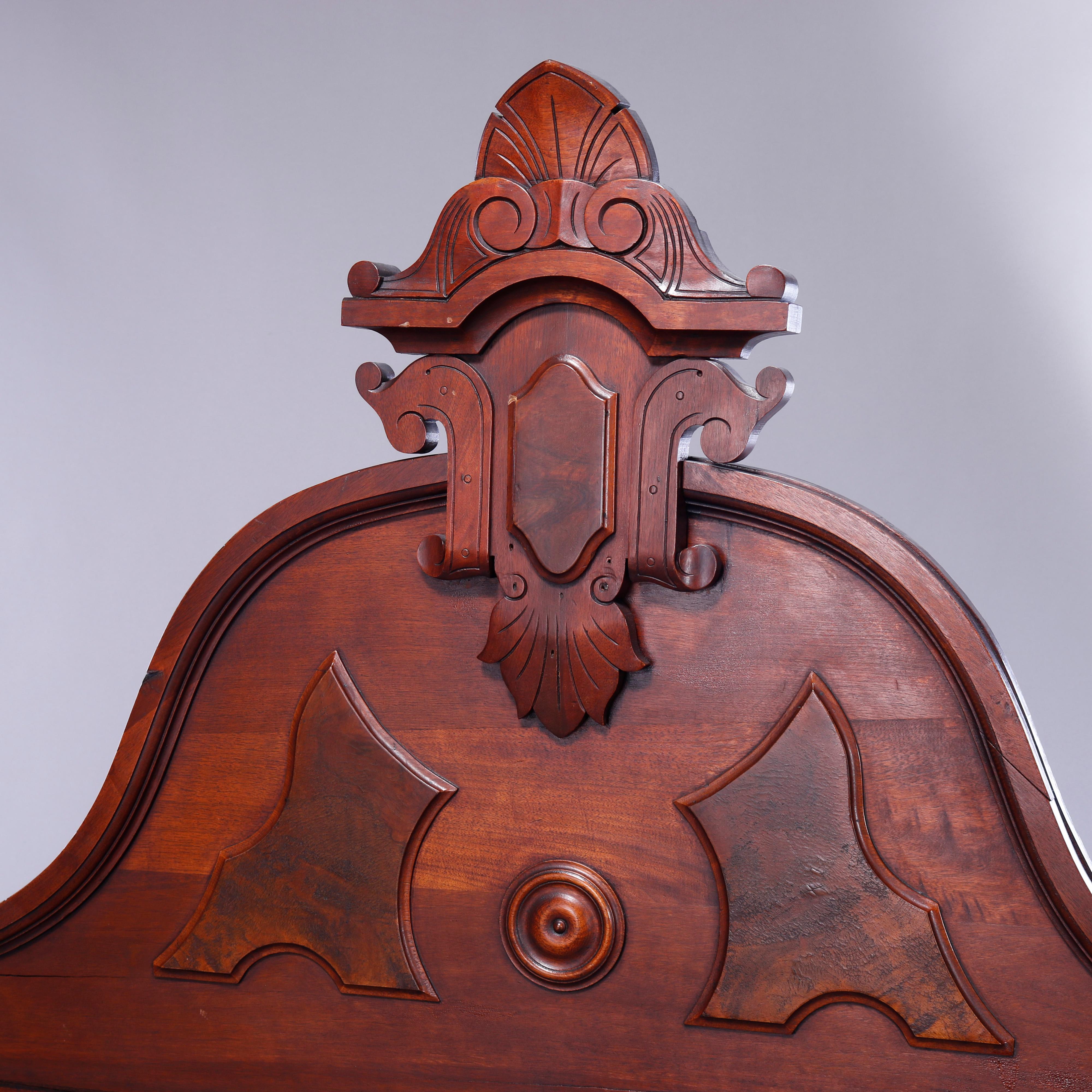 An antique Renaissance Revival bed frame offers carved walnut and burl paneled construction with shaped headboard having shield form cartouche with flanking urn finials, c1890

Measures- Overall 79