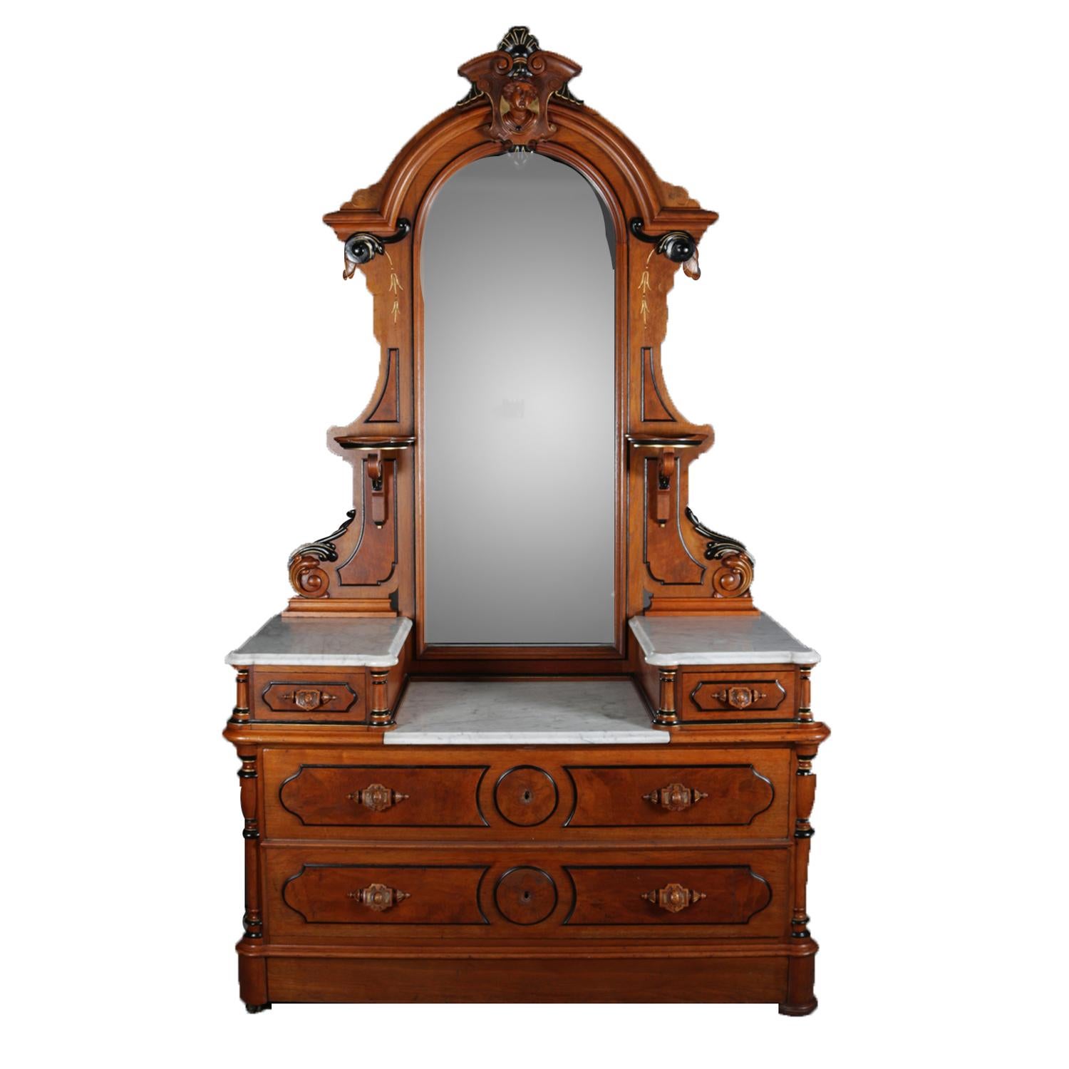 An antique Renaissance Revival dresser features drop centre form with dressing mirror having ebonized and gilt carved walnut and burl frame with crest having female mask and lower candle sconces, marble top case having flanking glove boxes over two