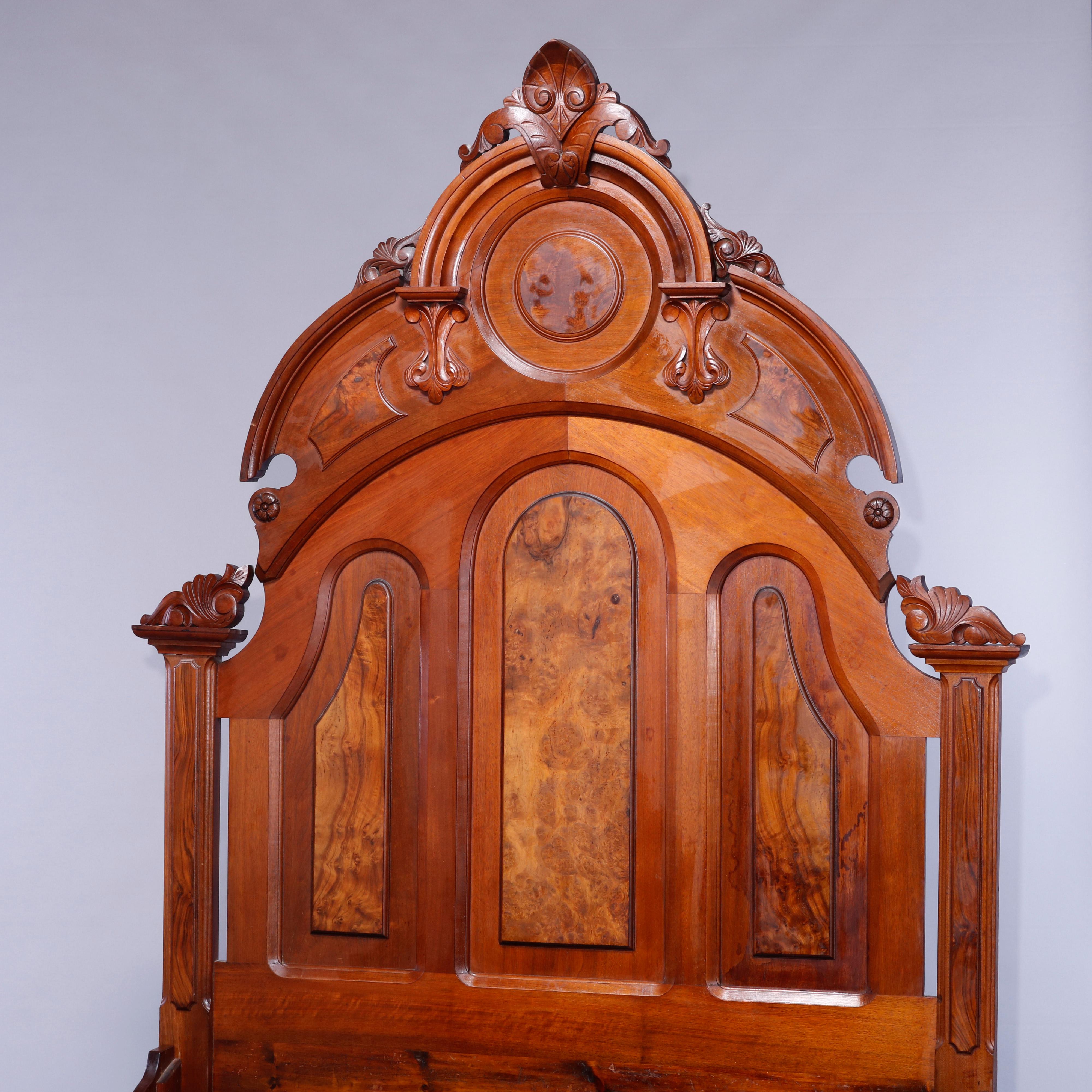 An antique Renaissance Revival full (or double) bed frame offers walnut and burl paneled construction with headboard having shaped crest with carved cartouche having flanking foliate elements, frame accepts full or double box spring and mattress