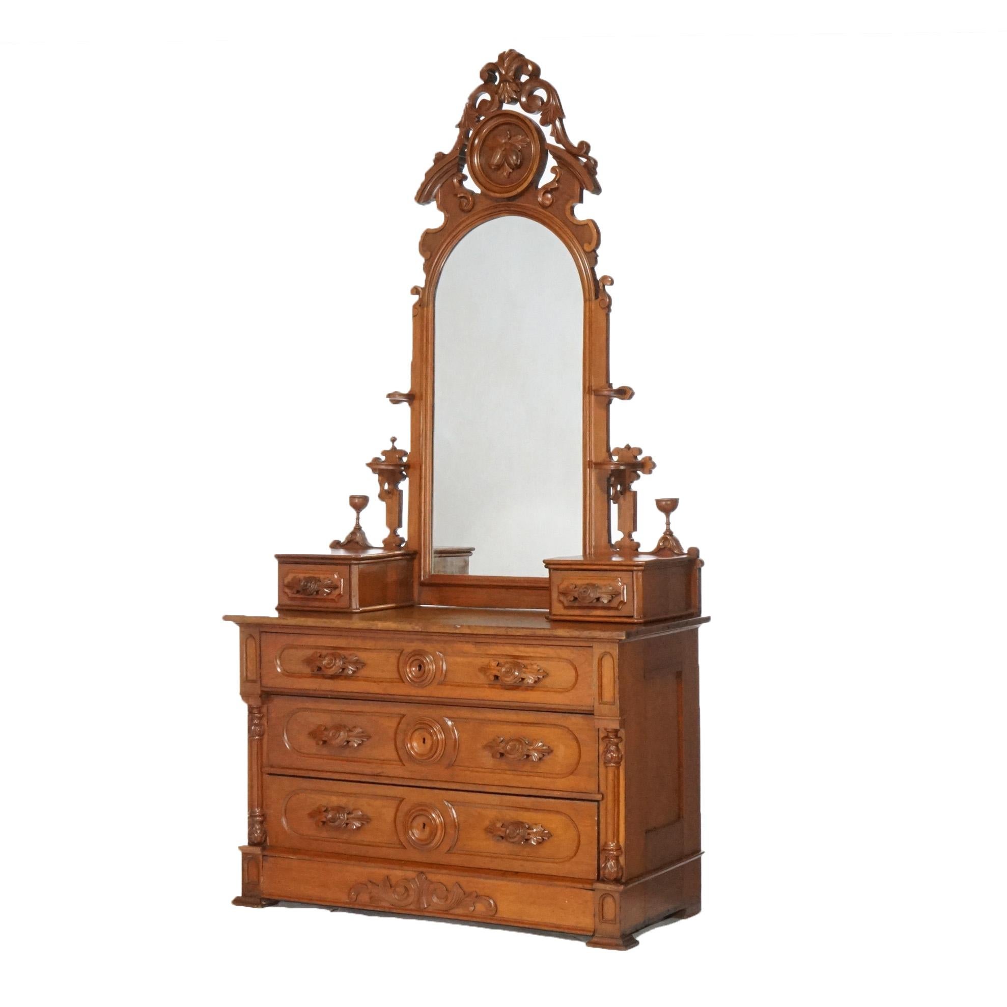 An antique Renaissance Revival mirrored chest of drawers offers dressing mirror with carved scroll and nut crest over dresser having three long drawers with flanking glove boxes and columns, circa 1880
Measures- 93.5''H x 49''W x 20.75''D.