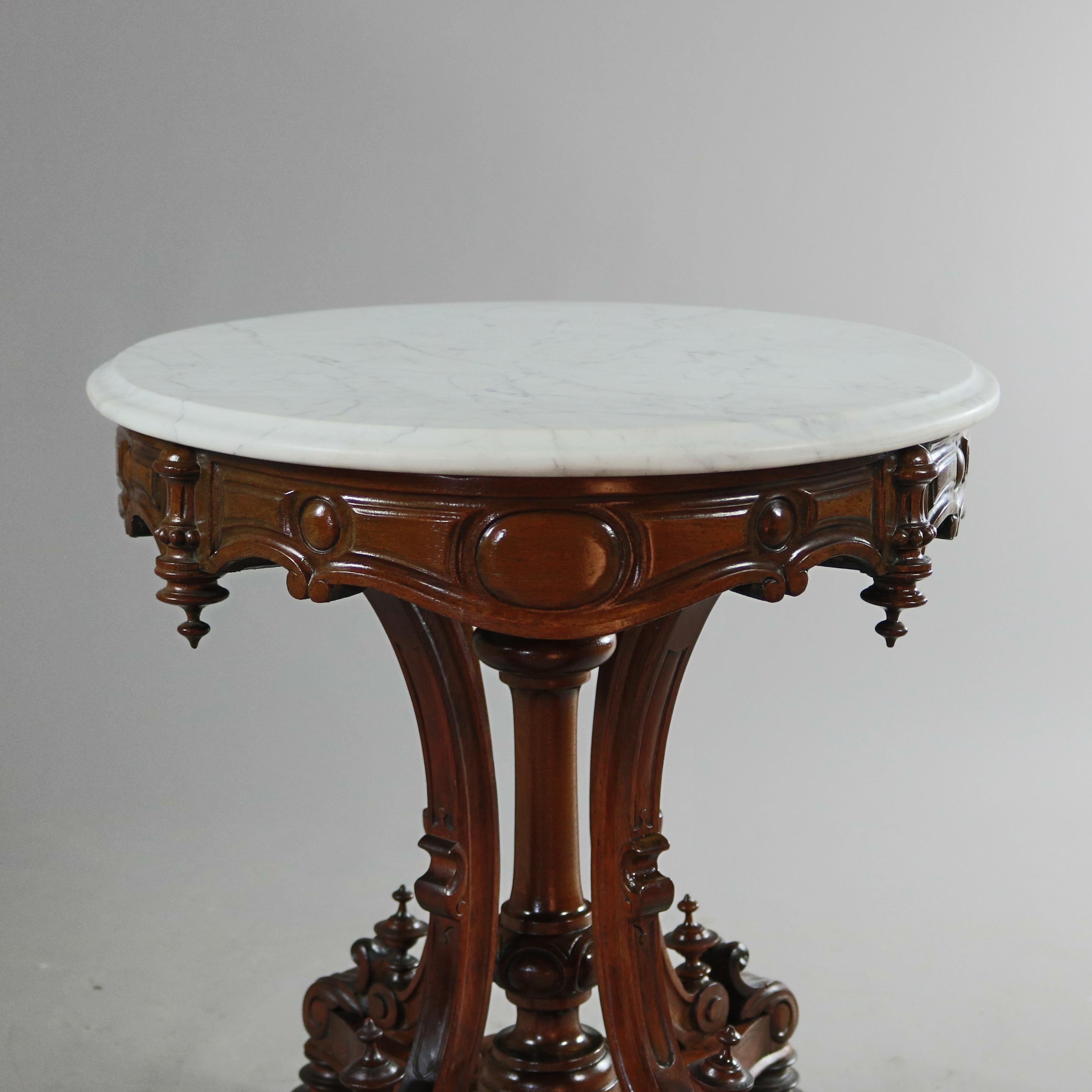 An antique Renaissance Revival center table offers bevelled marble top surmounting carved walnut frame with shaped skirt having drop finials and raised on scroll form legs seated on base with scrolled feet, circa 1880.

Measures: 29.5