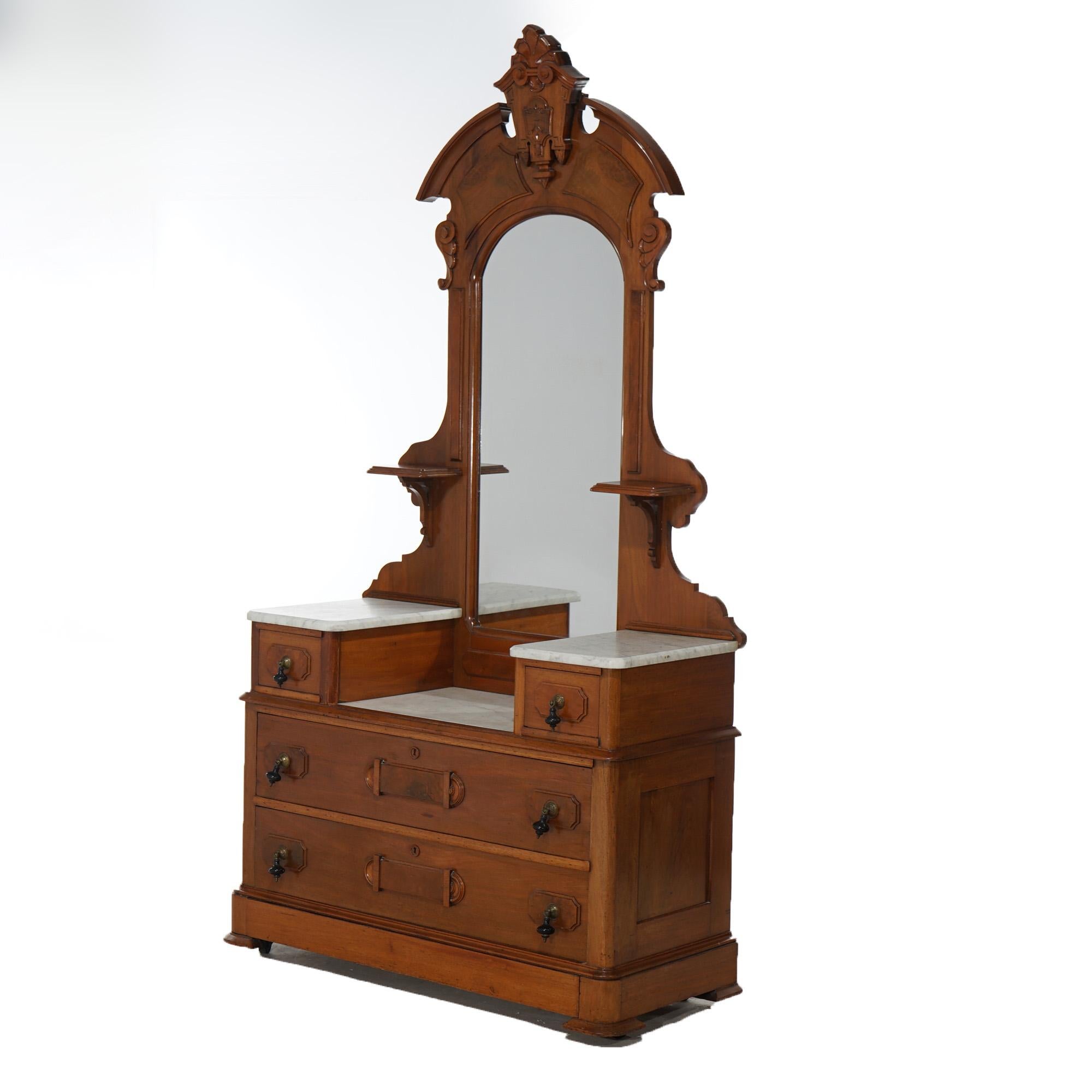 An antique Renaissance Revival drop center dresser offers walnut construction with mirror having carved shield form cartouche over drop center case with marble tops, raised panel drawers, and tear drop pulls, c1890

Measures- 87''H x 45''W x 20''D