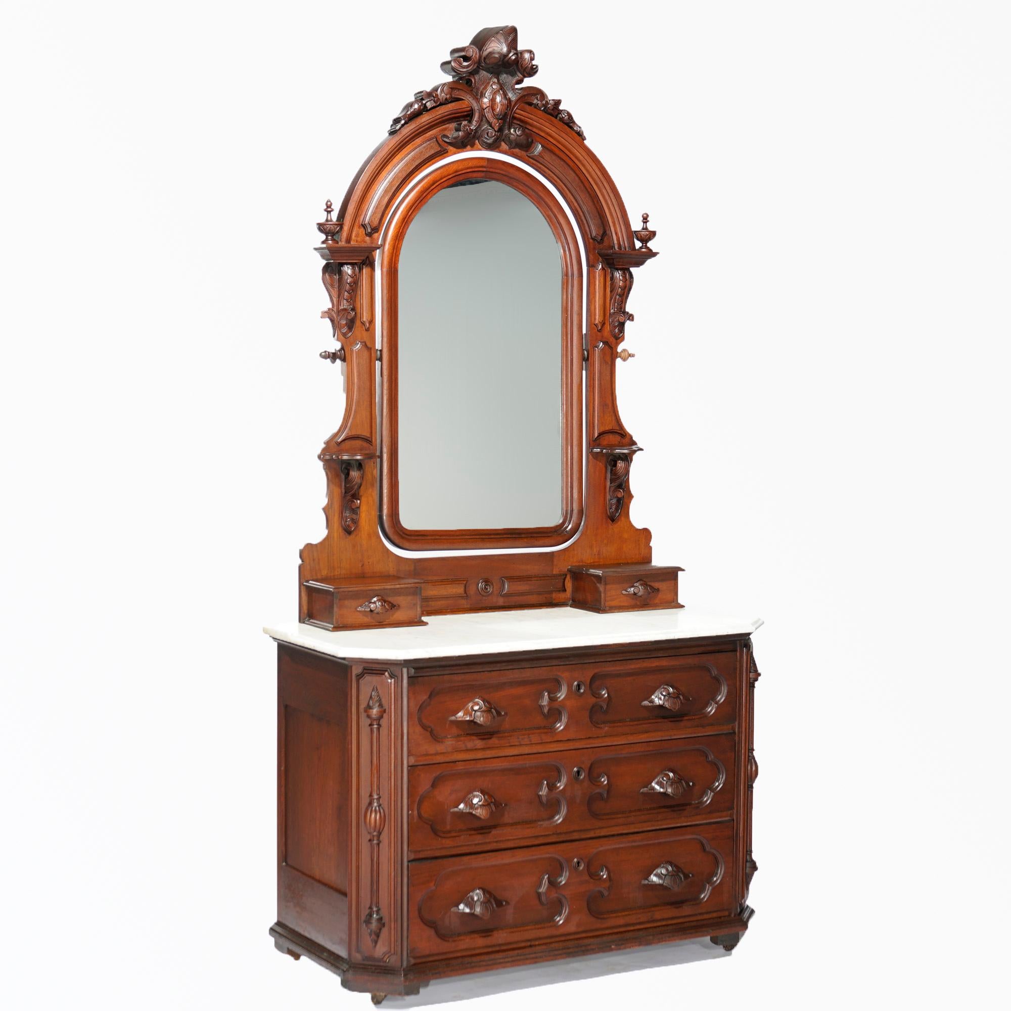 An antique Renaissance Revival dresser offers walnut construction with arched mirror having shield form cartouche and carved foliate elements over marble top case with foliate carved pulls, Gould, Philadelphia maker mark stenciled as photographed,