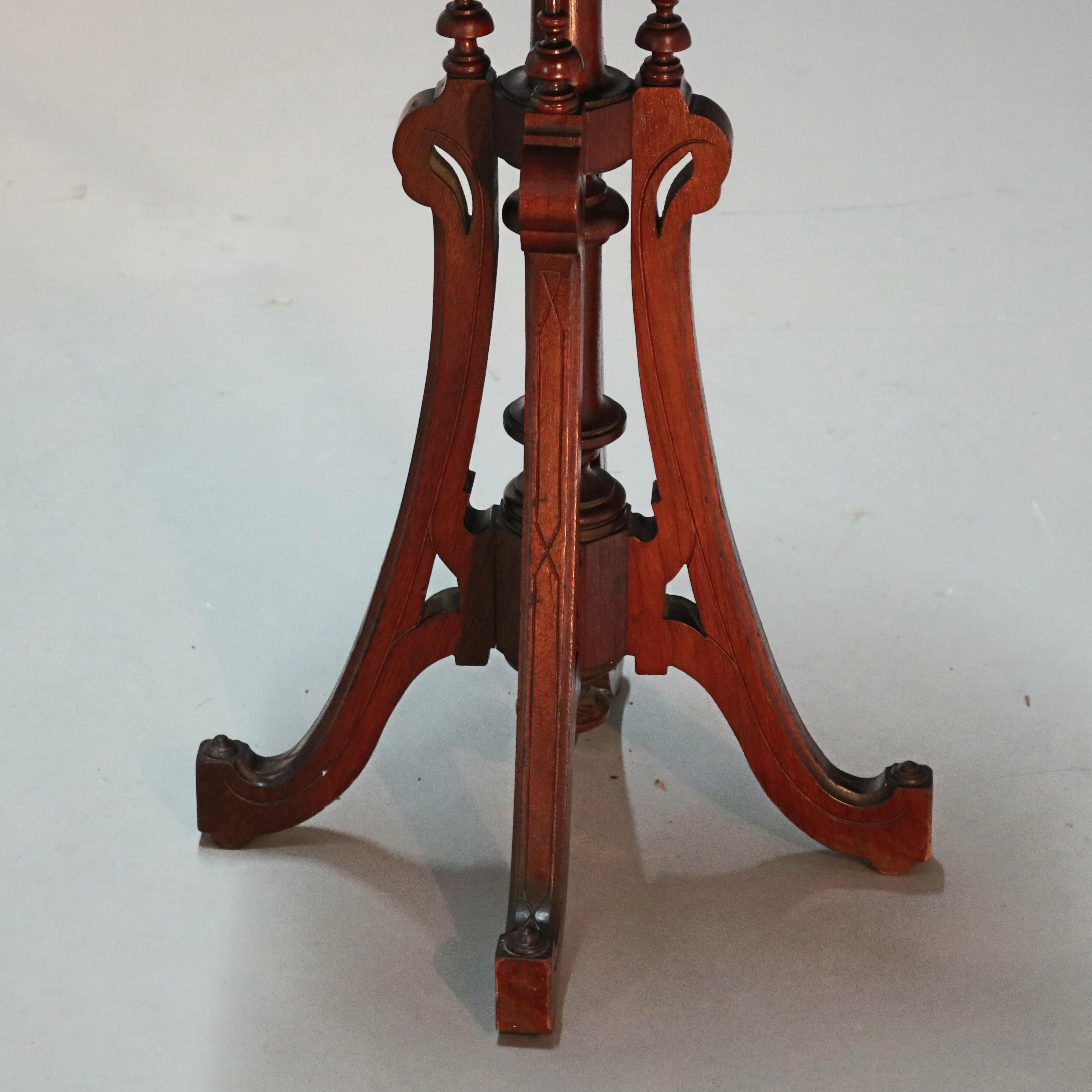 An antique Renaissance Revival fern plant stand offers beveled marble top surmounting walnut base with carved and inscribed shaped skirt raised on turned column having bowed legs with stylized goose head capitals, finials and terminating in stylized