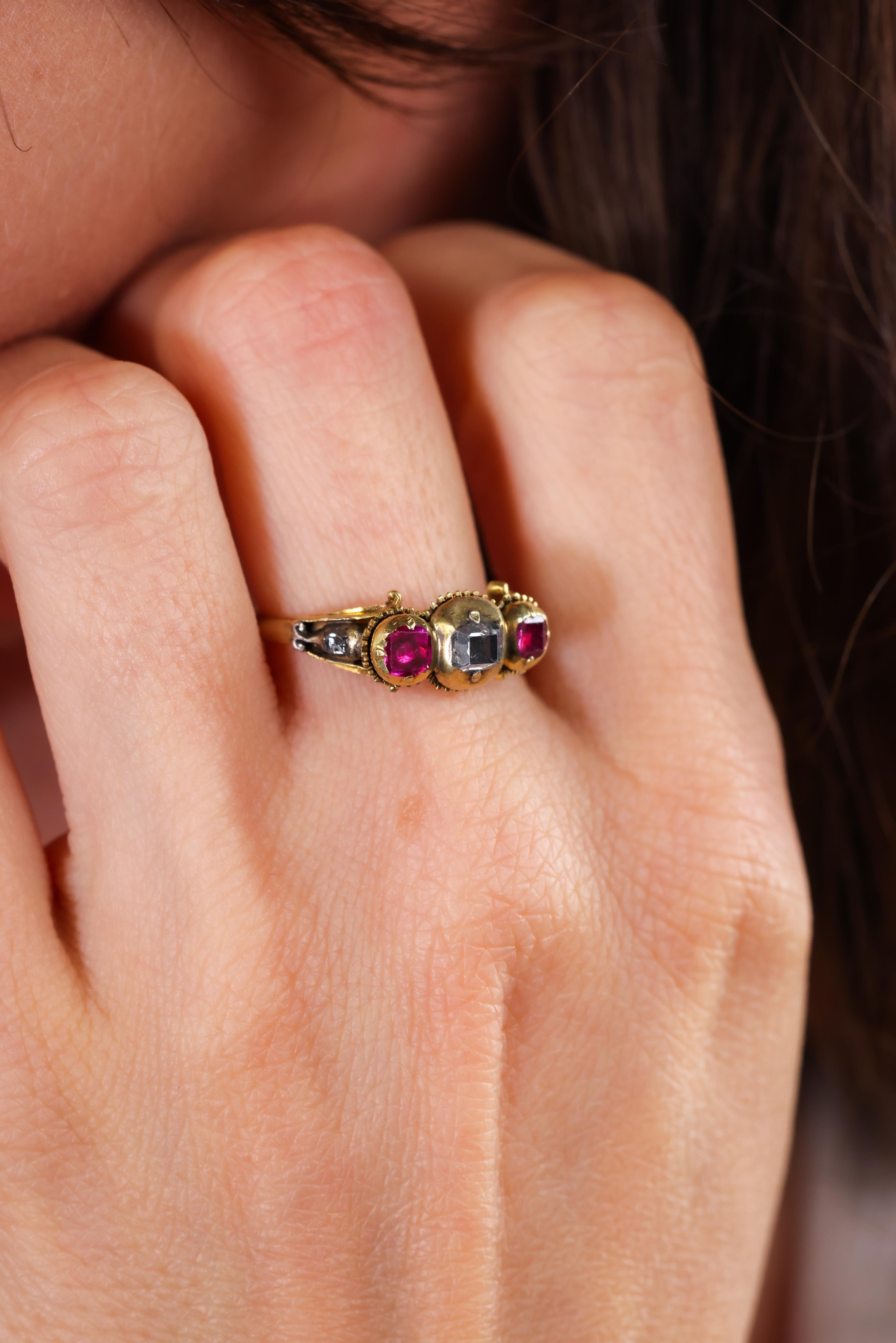 Mittelstein: 3 Diamanten
Schneiden: Tabelle
Gewicht: ca. 0,50 Karat 
Farbe: F-G  
Klarheit: SI 
Akzent-Stein: 2 Rubine 
Schneiden: Tabelle
Gewicht: ca. 0,35 Karat 
Metall: 18k Gelbgold 
Epoche: Renaissance-Revival 
CIRCA: 1840er Jahre 
Größe: 6-1/4