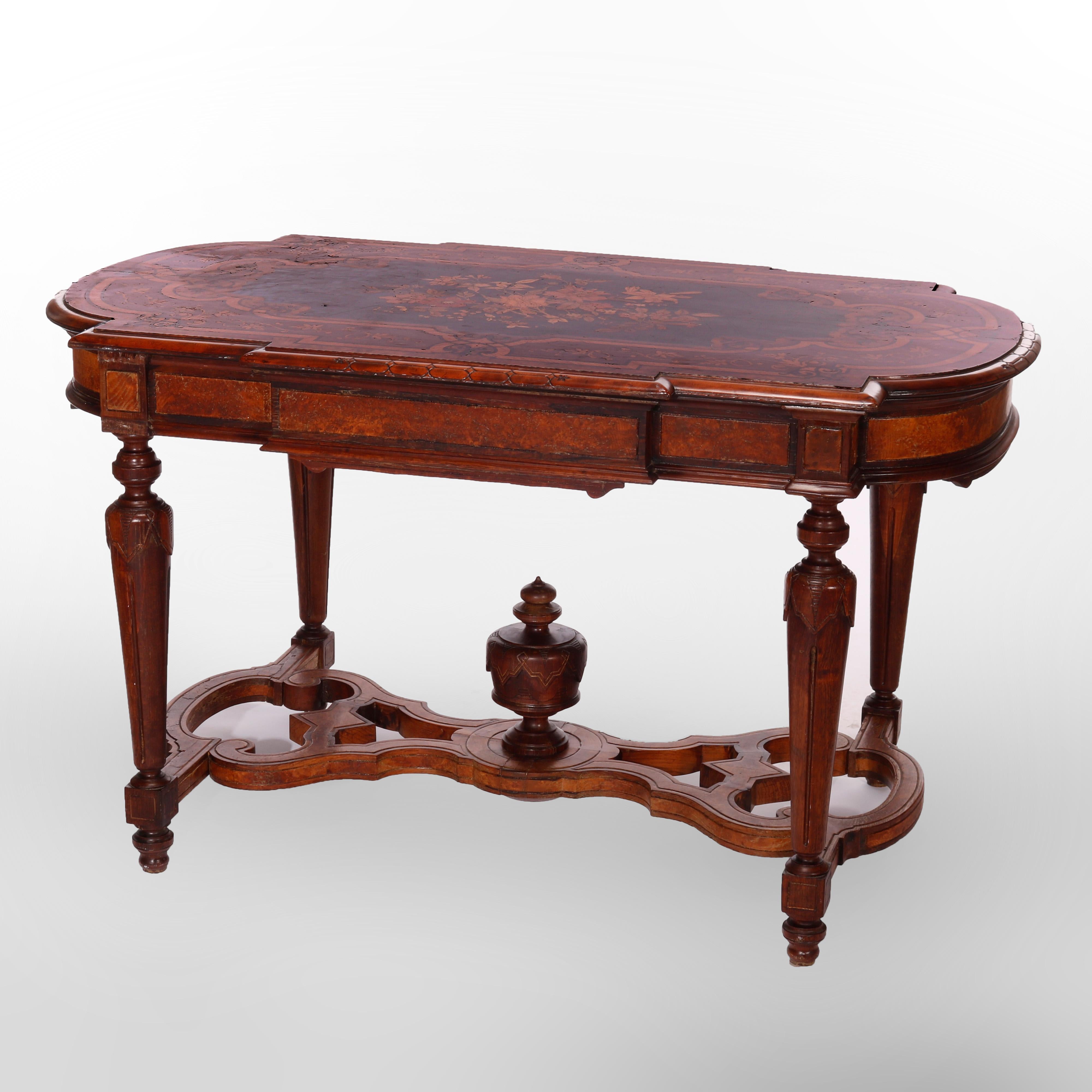 An antique Renaissance Revival center table offers walnut construction with shaped top having inlaid and ebonized reserve with floral marquetry, skirt with burl reserves, raised on carved balustrade legs having cutout stretcher with urn form finial,
