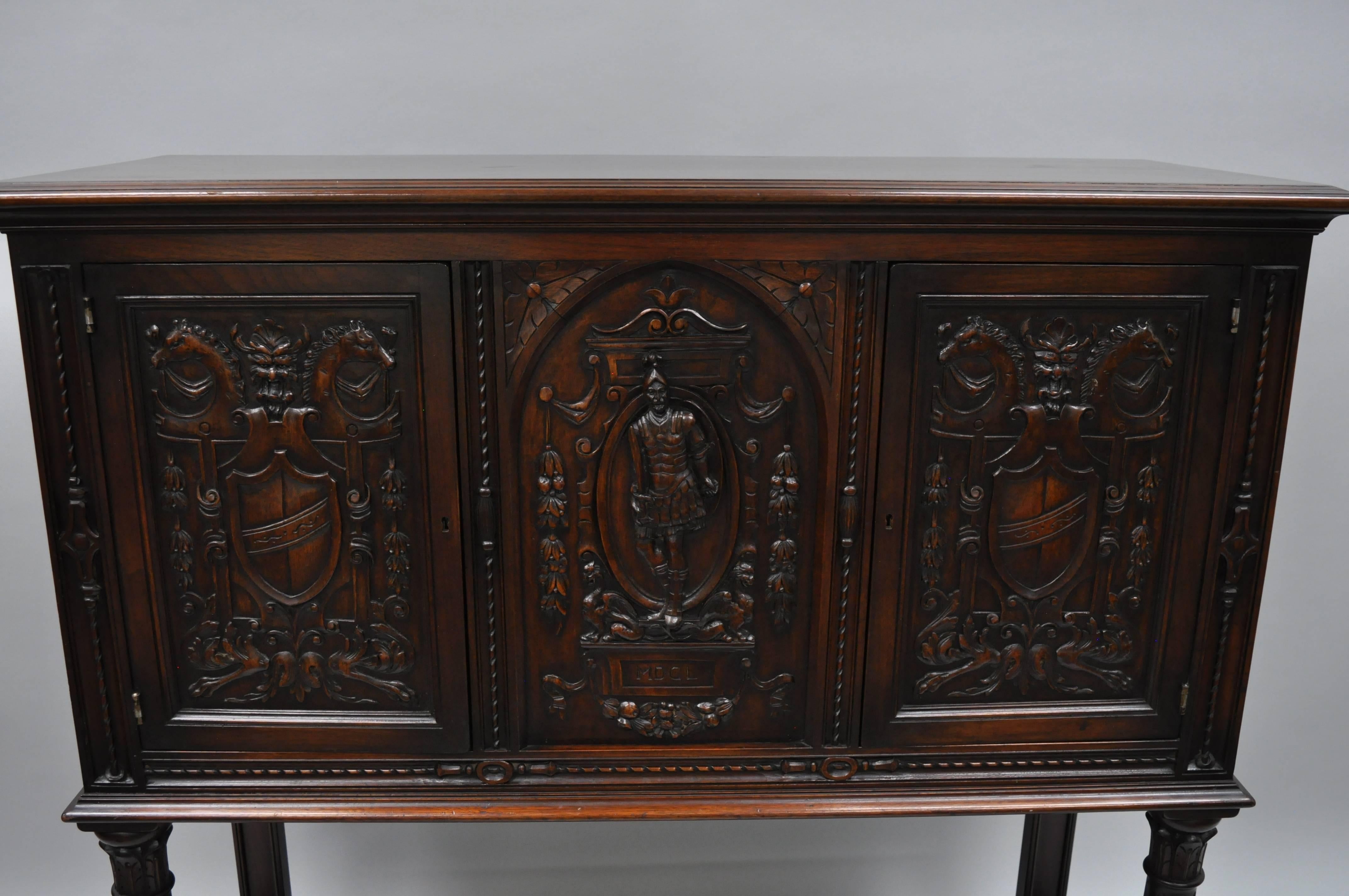 Antique Renaissance Revival figural carved walnut cabinet. Item features ornately carved walnut panels of shields and crests, horse heads, as well a central soldier. Cabinet has two swing doors, carved support columns, lower shelf, panel back, and