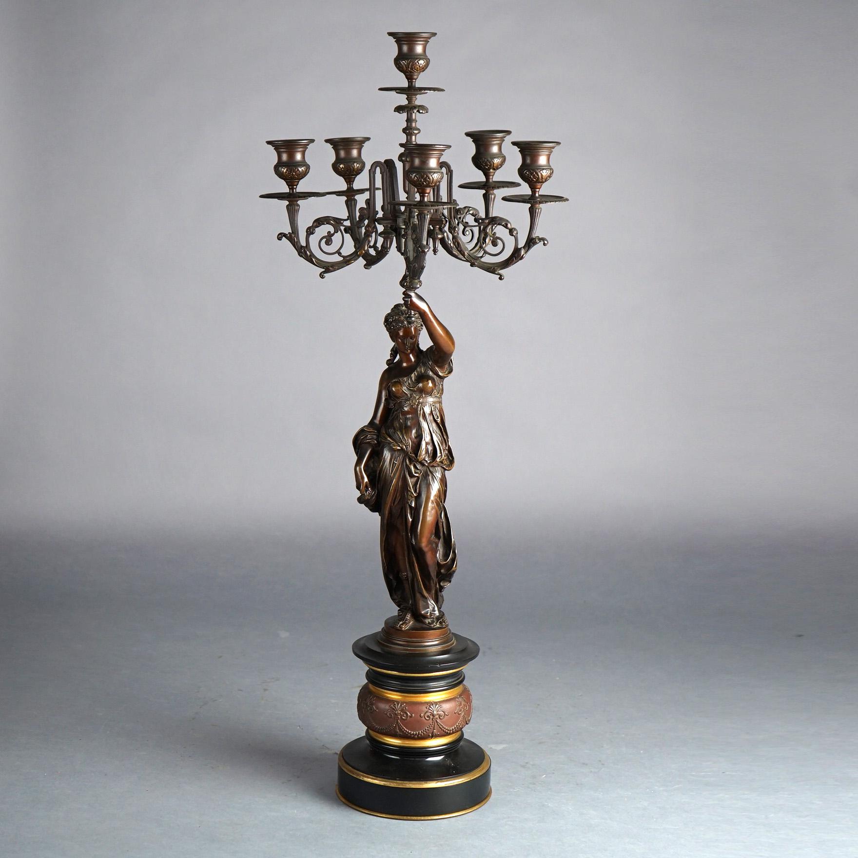 An antique Renaissance Revival figural garniture set offers central slate clock with mother daughter or sisters bronzed sculpture signed Paul Dubois (French, 1829-1905) and matching pair of figural torchiere candelabra depicting bridal party or