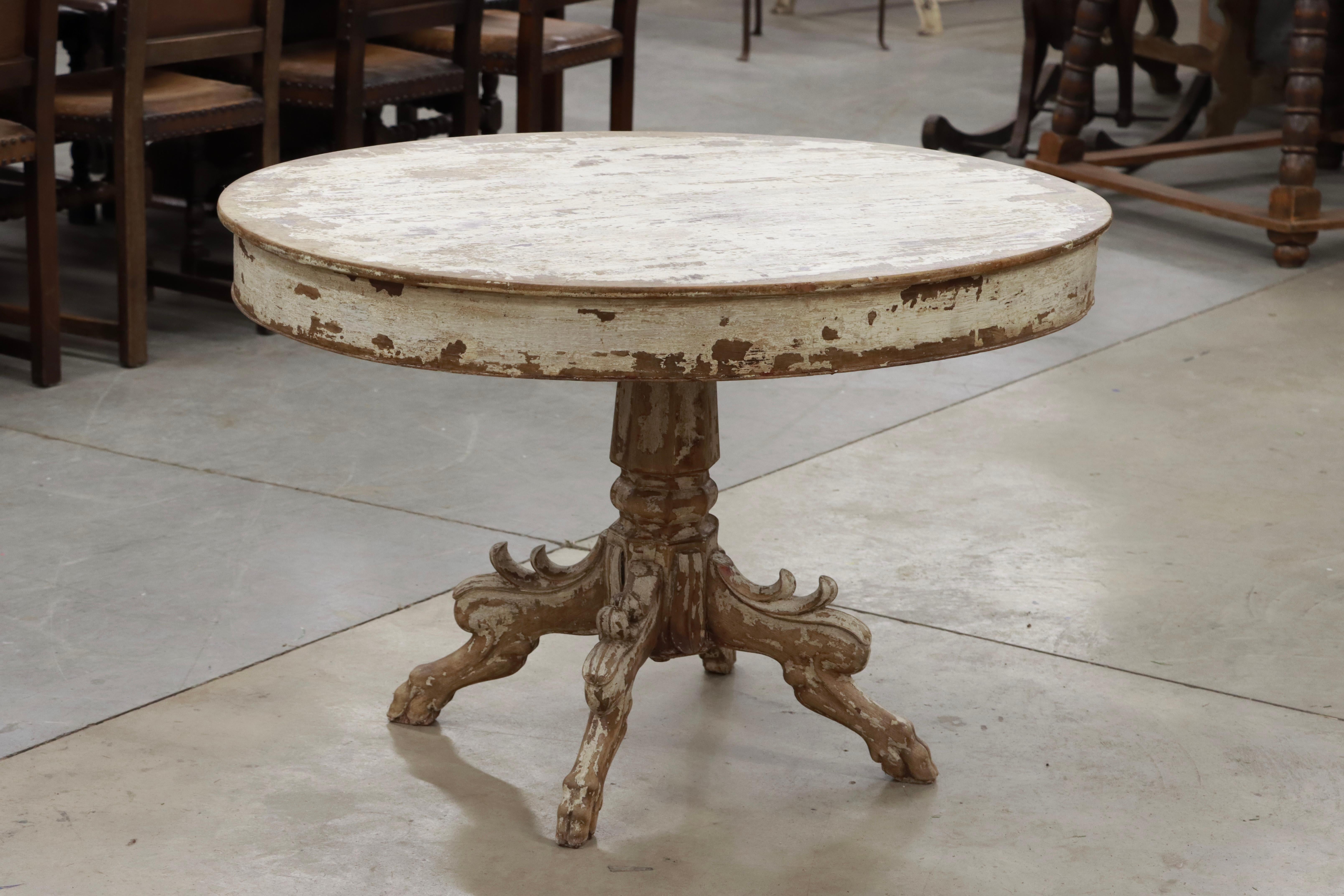 Antique French Renaissance Revival oval walnut centre table. The solid plank top is supported by a simple edged apron. The central baluster has four legs carved with acanthus leaves . 

The overall unpretentious look of the table with its distressed