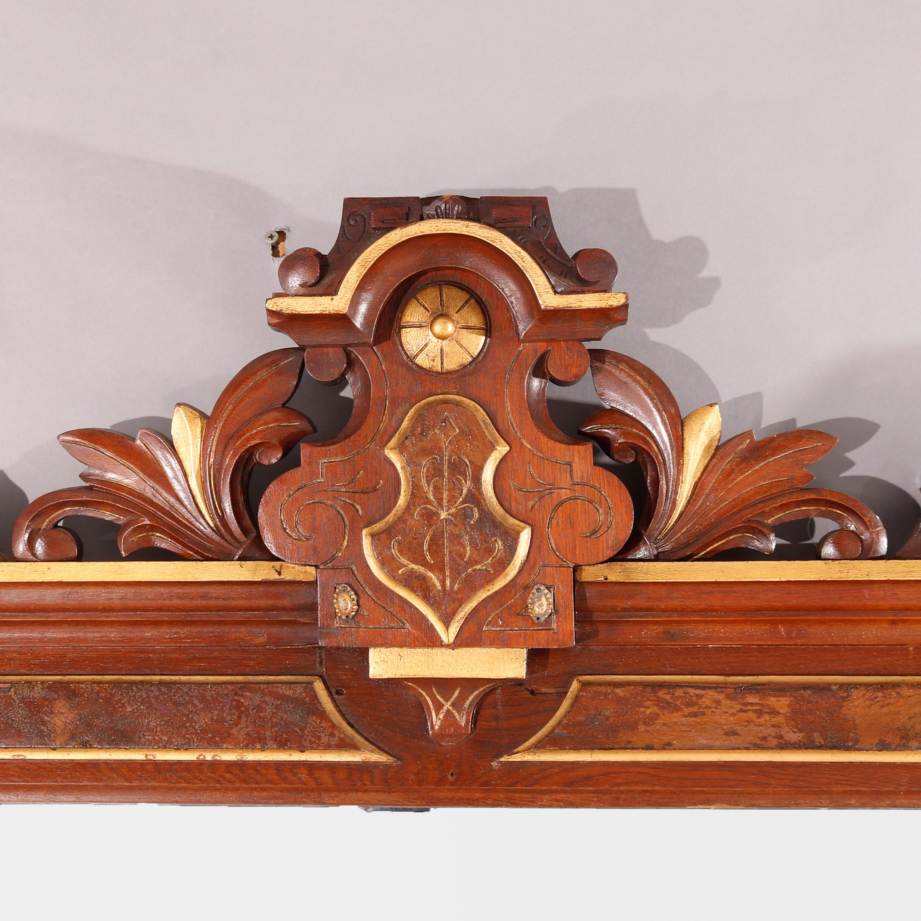 An antique Renaissance Revival over mantle mirror offers walnut construction with stylized foliate crest over framed mirror with burl inset and gilt highlights throughout, circa 1880

Measures - 74.5
