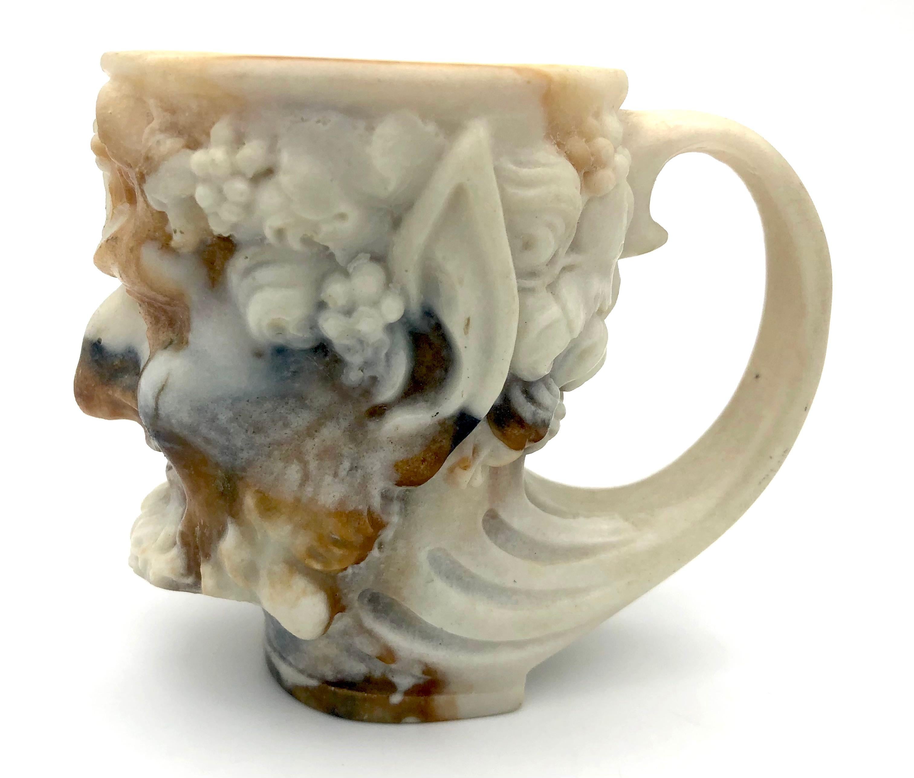 This wonderful beaker in the shape of a faun has been molded out of thick marbled glass.